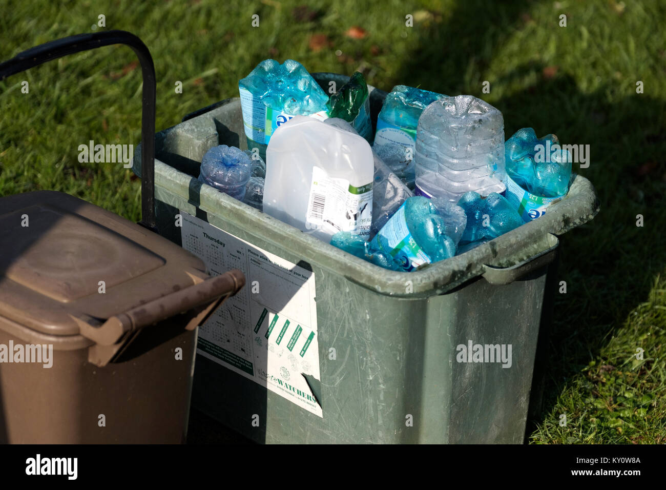Un ente locale di riciclaggio di rifiuti al di fuori di una casa per la raccolta e il riciclaggio. È pieno di assortiti di plastica Imballaggi di plastica e contenitori di fluido Foto Stock