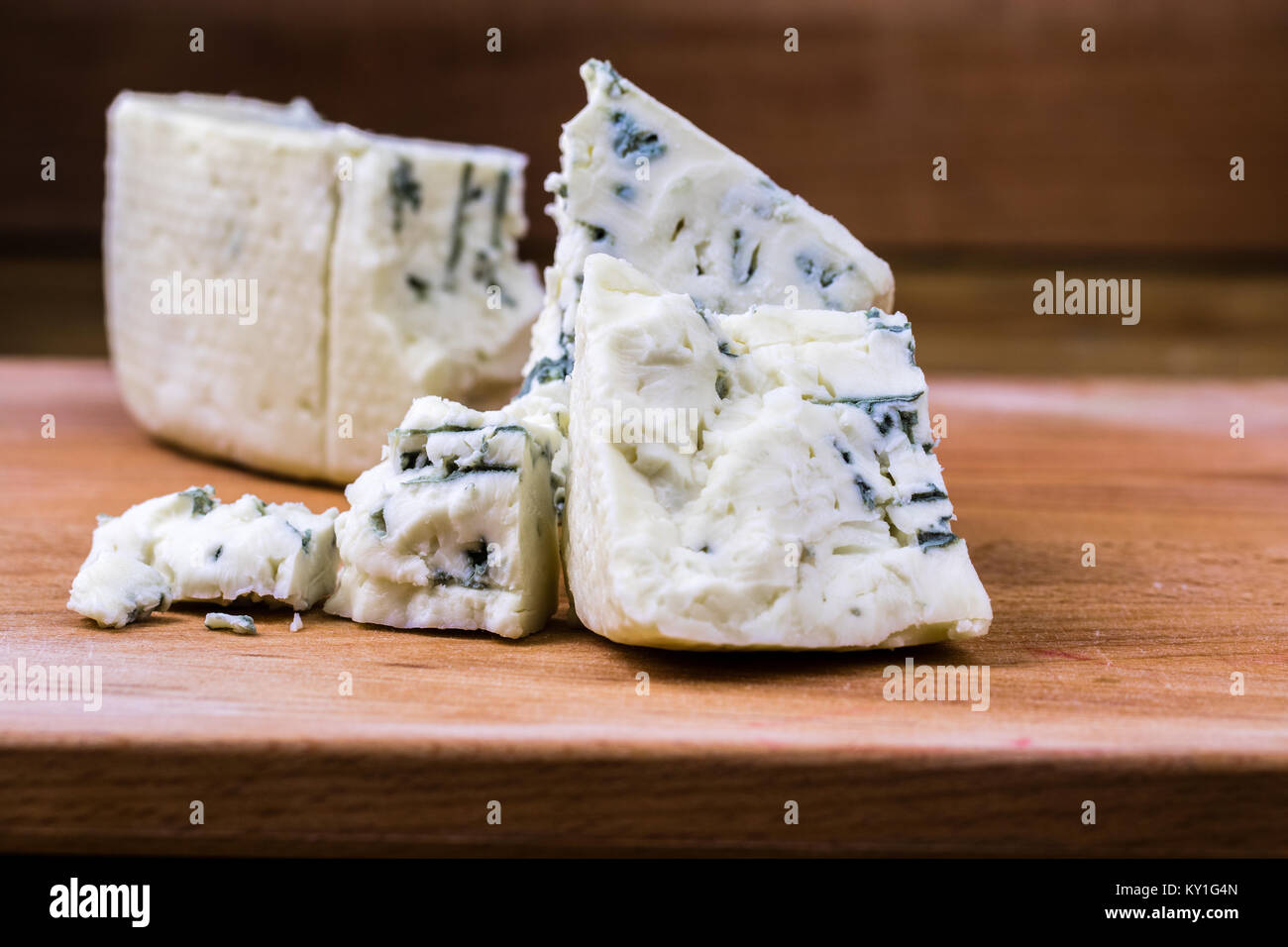 Blu danese o il roquefort e macro shot sul tagliere con bordi grossolani e ammuffito vene esposta. Foto Stock