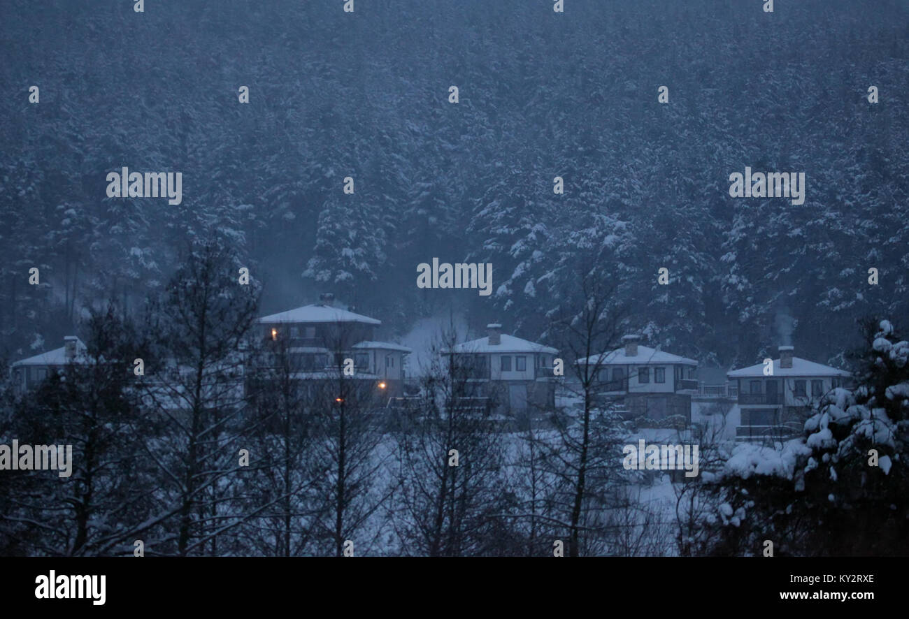 Dramatik inverno Neve paesaggio notturno oltre le piccole case in montagne bulgare Foto Stock