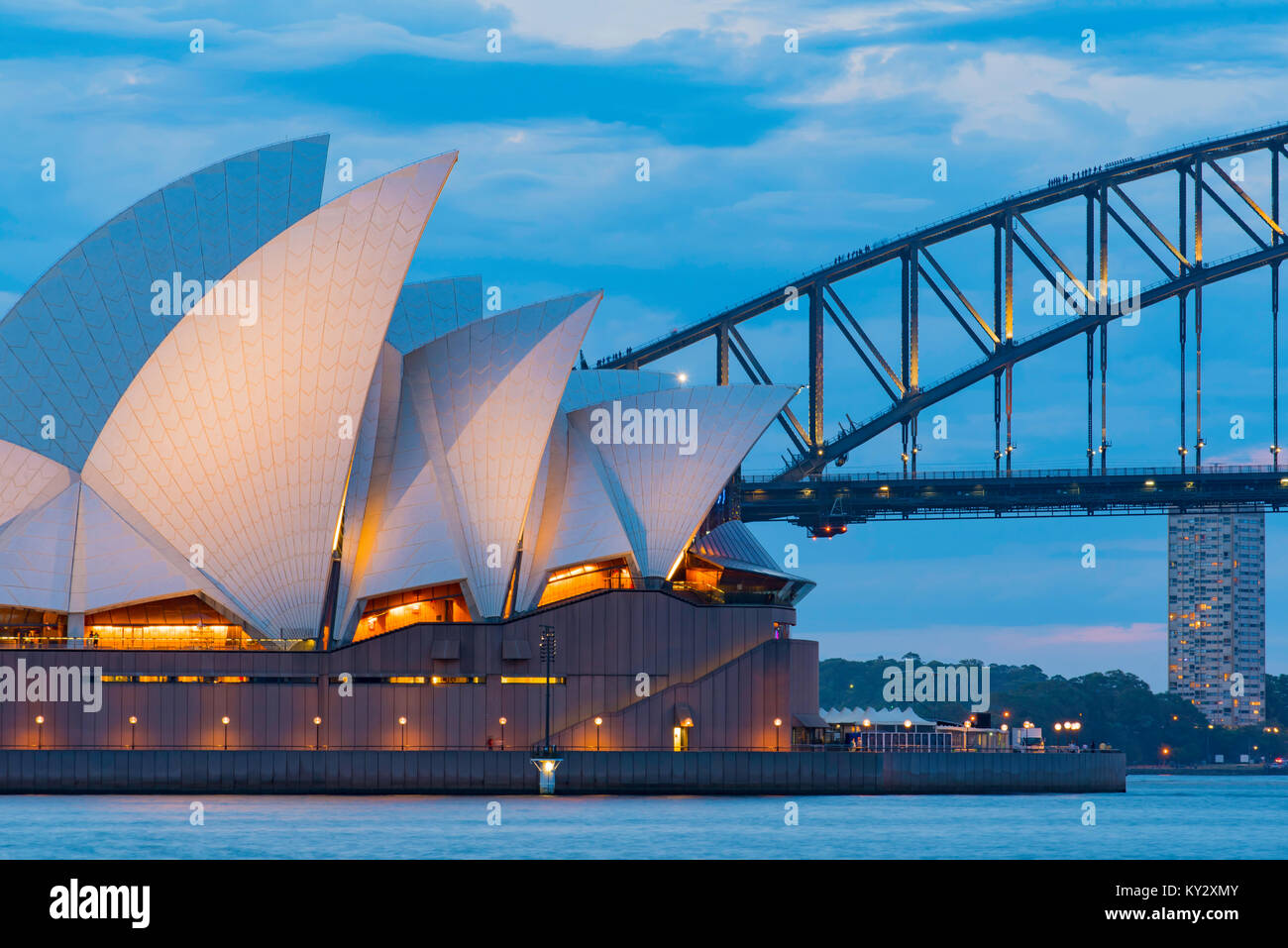 Il Sydney Harbour Bridge e Opera House illuminato solo sul tramonto visto dal Royal Botanic Gardens Foto Stock