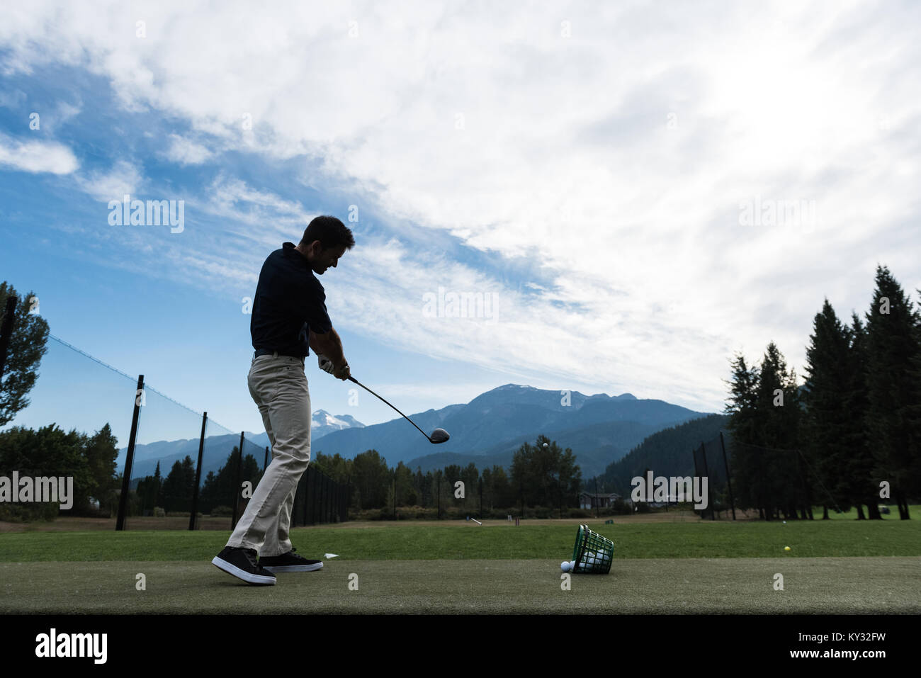 Uomo di eseguire una oscillazione di golf Foto Stock