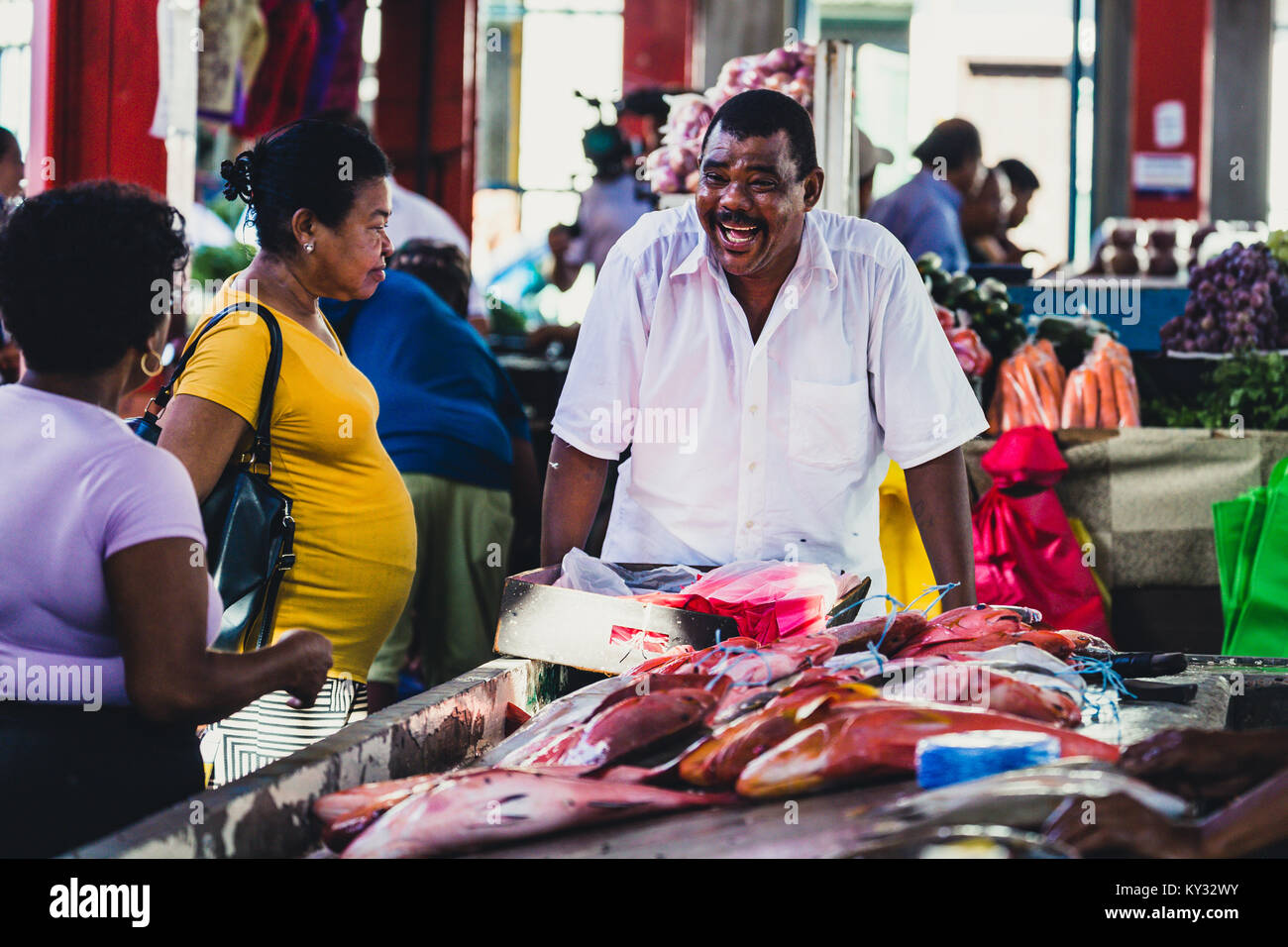 Pescatore africano vendere il suo pesce del mercato proprie di una donna, Seicelle Foto Stock
