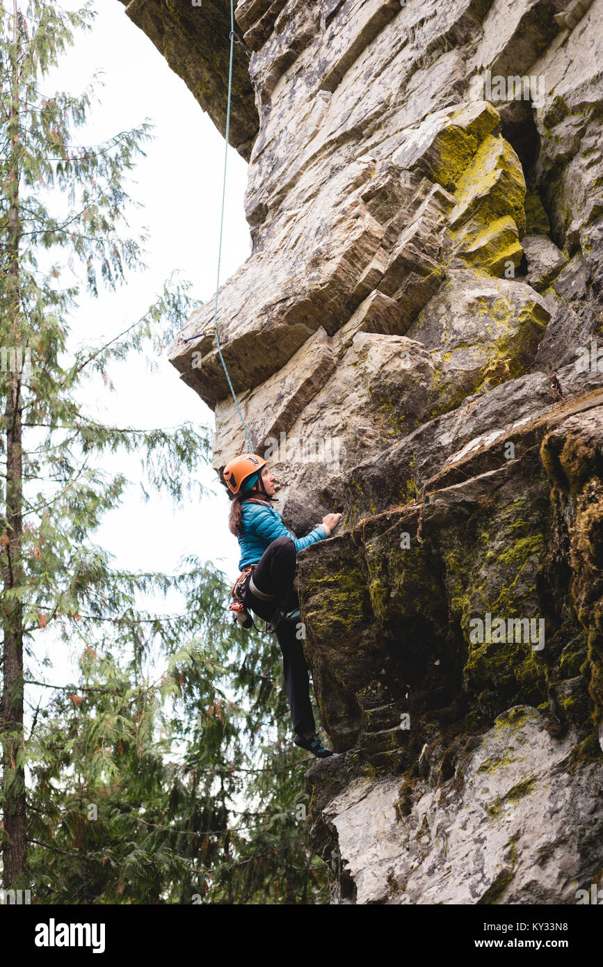 Scalatore femmina arrampicata la scogliera di roccia Foto Stock