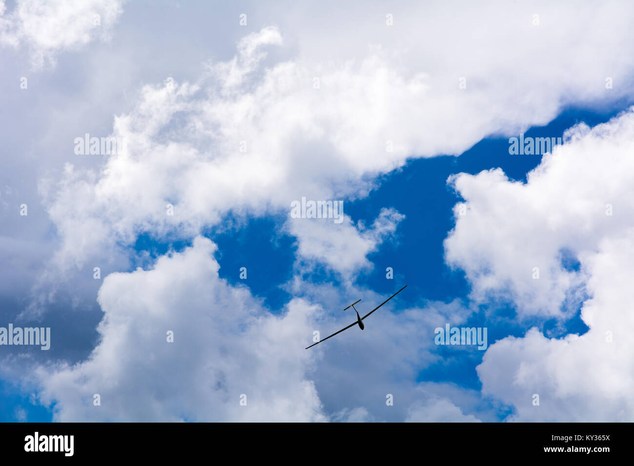 Un parapendio vola nel cielo blu con grandi nuvole bianche. Il parapendio è un piano che non ha il motore Foto Stock