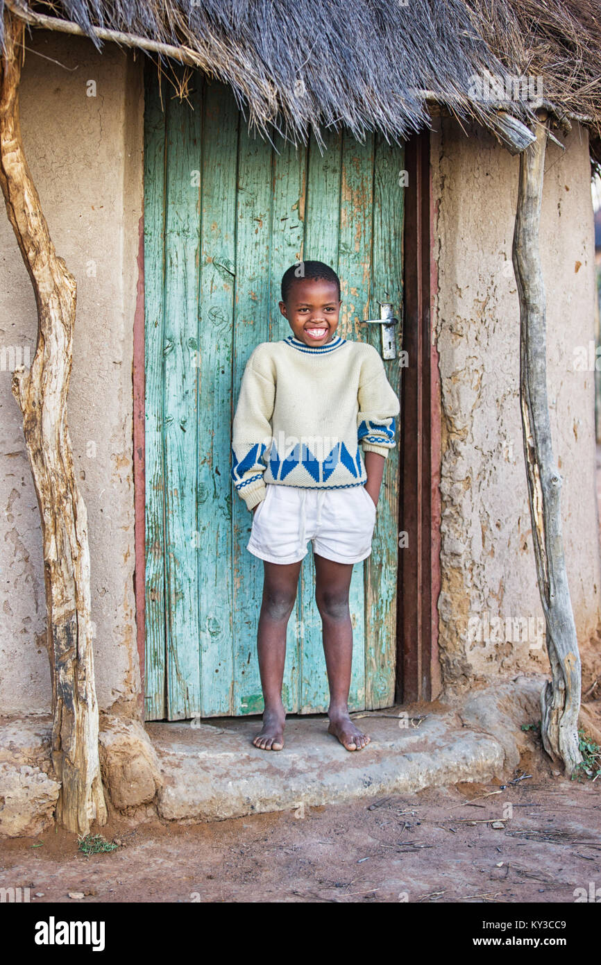 Motswana africana bambino seduto nella porta della baracca Foto Stock