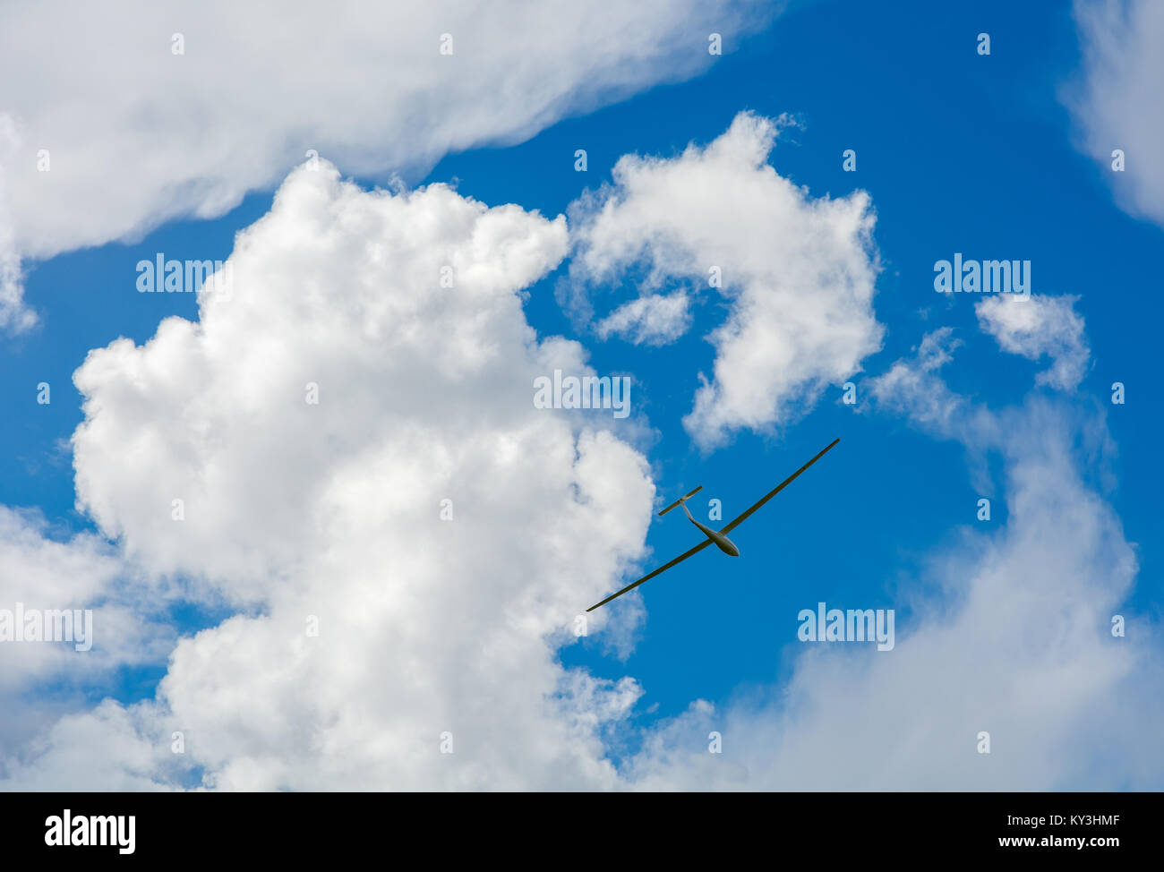 Un parapendio vola nel cielo blu con grandi nuvole bianche. Il parapendio è un piano che non ha il motore Foto Stock