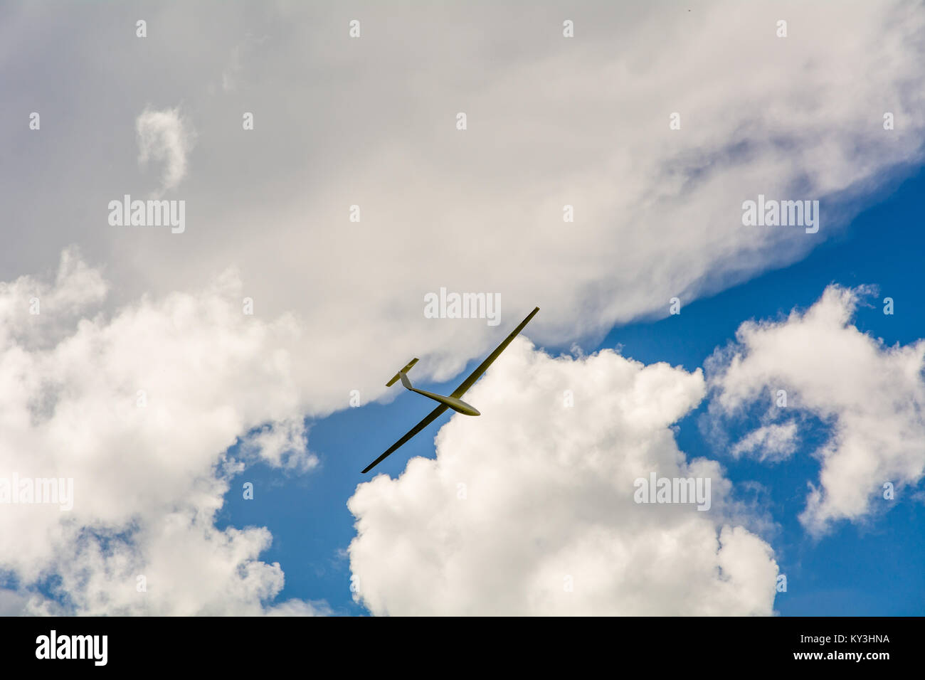 Un parapendio vola nel cielo blu con grandi nuvole bianche. Il parapendio è un piano che non ha il motore Foto Stock