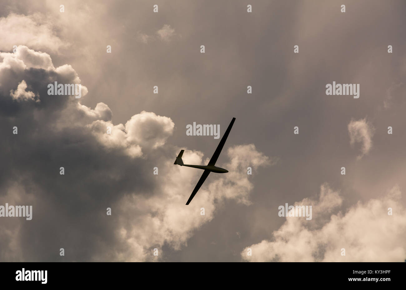 Un aliante che vola in cielo con grandi nuvole minacciose. Il parapendio è un piano che non ha il motore Foto Stock