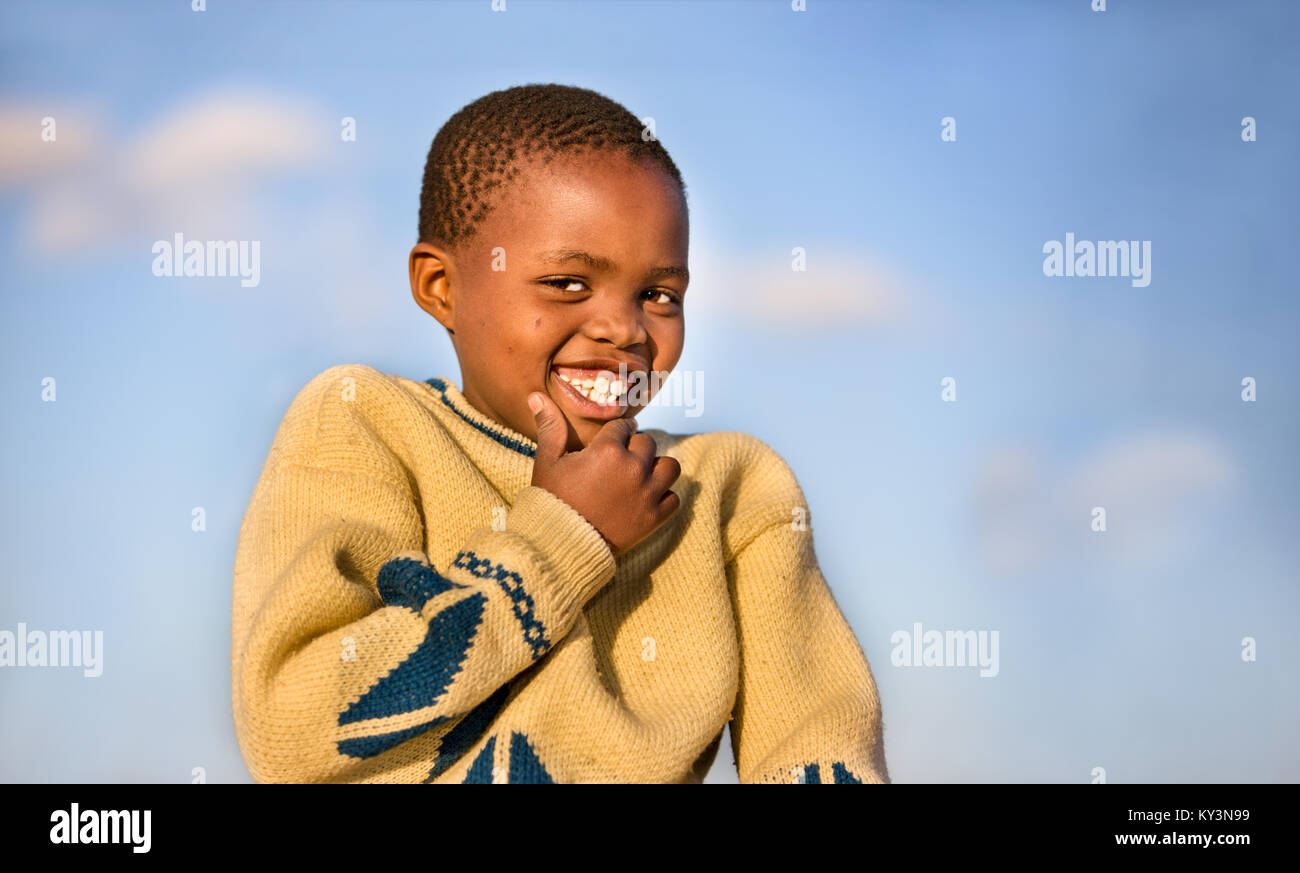 Motswana bambino sorridente contro lo sfondo del cielo Foto Stock
