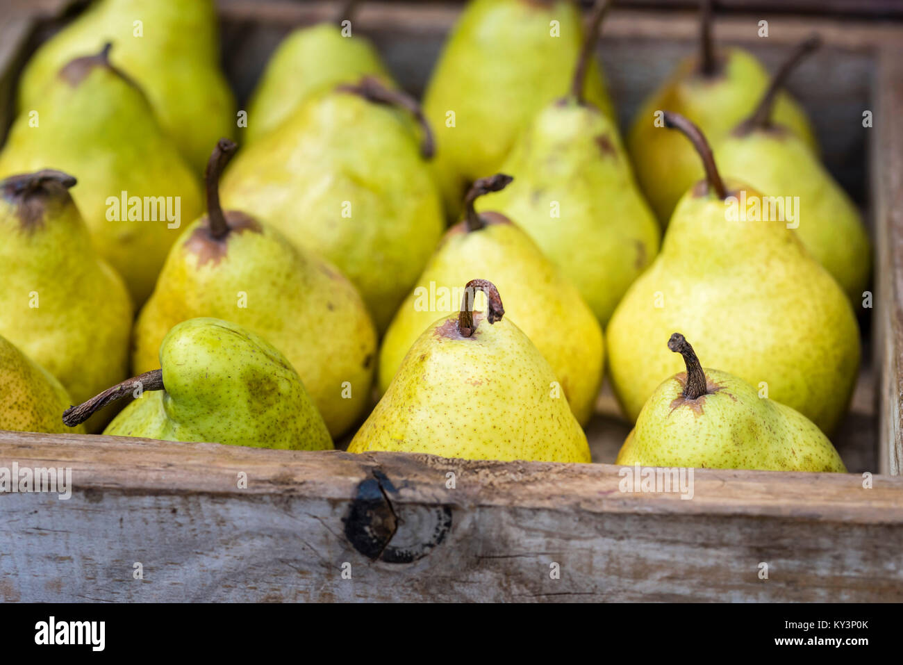 Giallo Williams (Bartlett) pere in scatola di legno, primo piano, lo sfondo. Fresca frutta organica visualizzare al mercato, vista laterale. Foto Stock