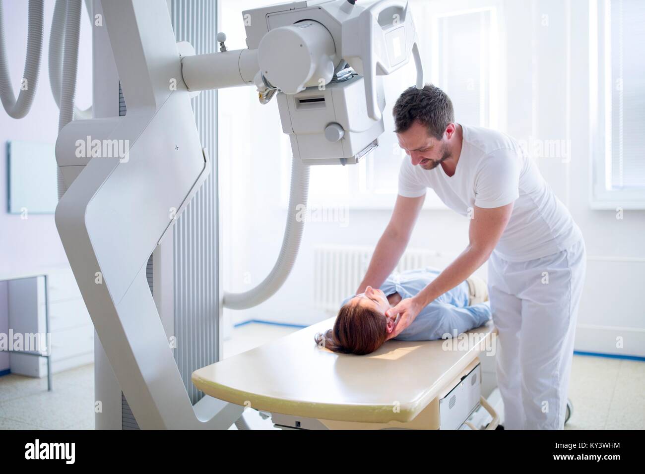 Medico femmina regolazione collo del paziente prima di un esame a raggi x. Foto Stock