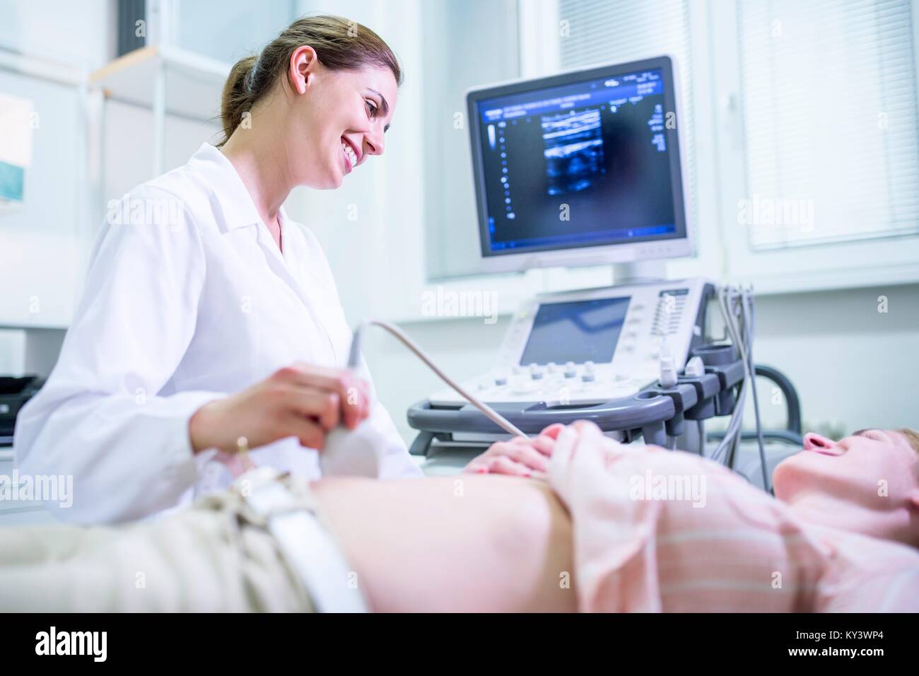 Ecografista eseguendo ultrasuoni sul paziente femmina. Foto Stock