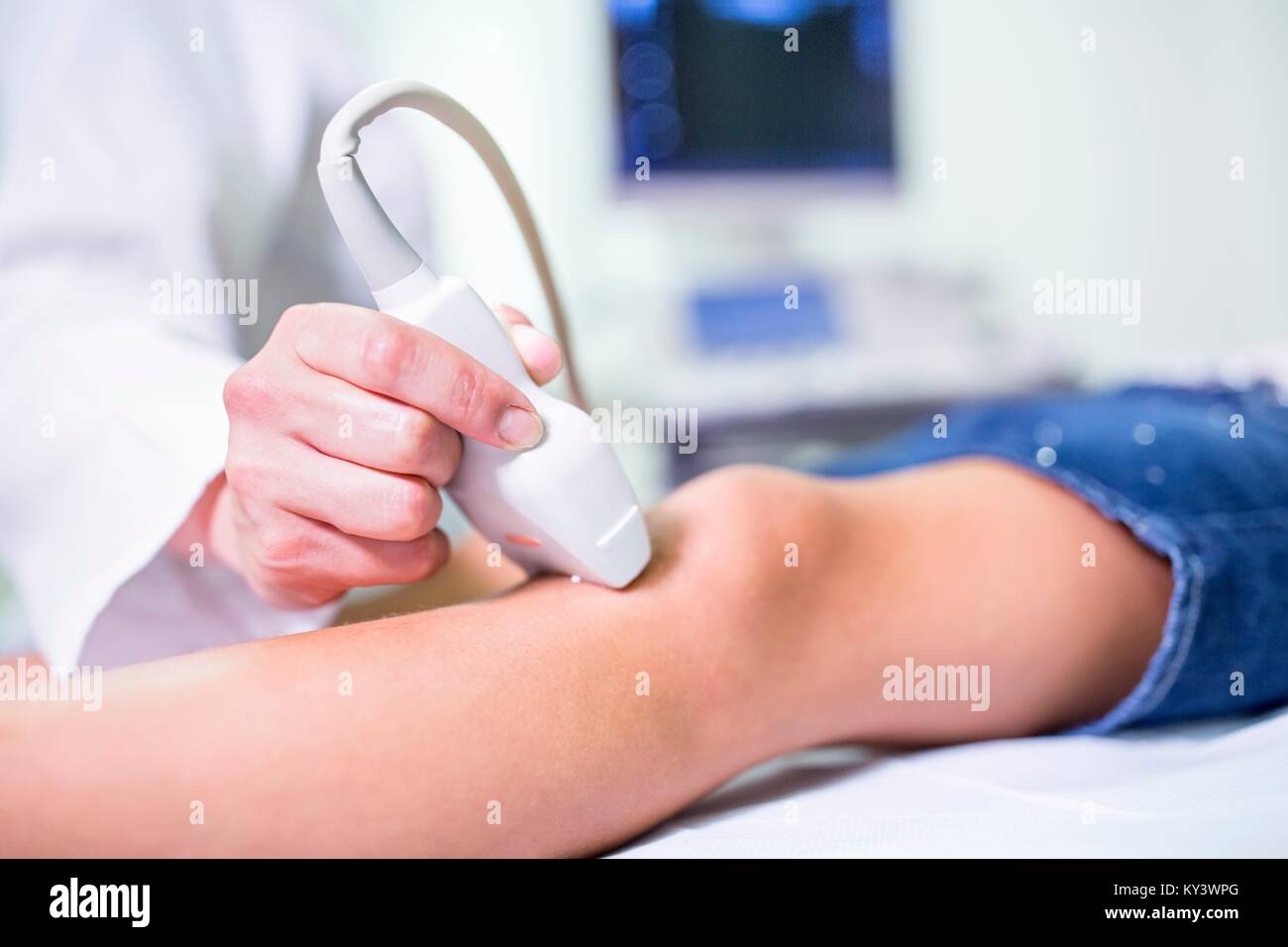 Ecografista esegue Ultrasound su ragazza in gamba. Foto Stock