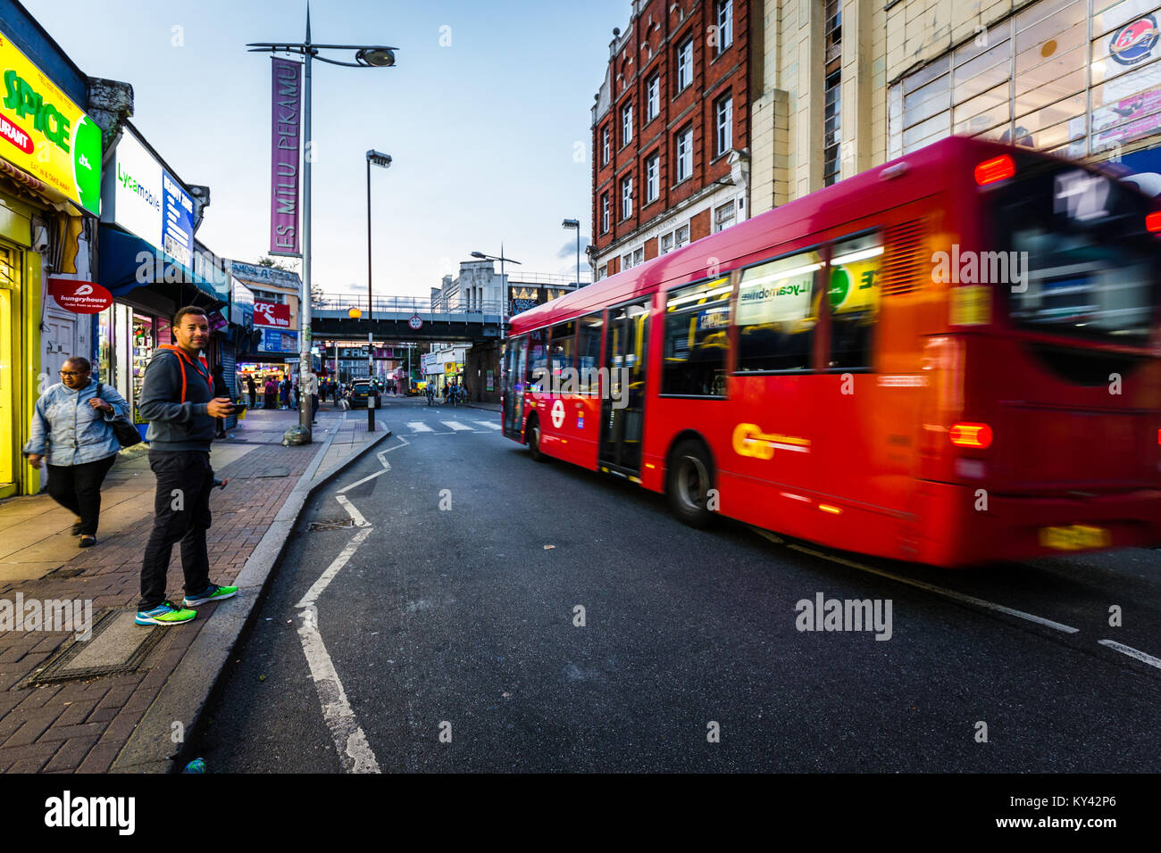 Scena di strada in Peckham, Londra, con bus rosso Foto Stock