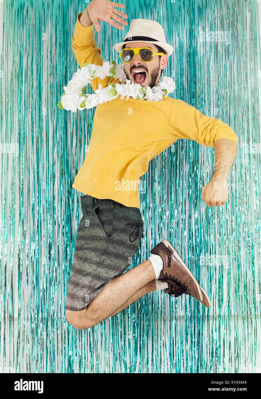Uomo Barbuto in verde e giallo vestiti, occhiali da sole e Collane Hawaiane.  Il Carnevale del Brasile, vigilia della festa di fine anno, euforia e  divertimento. Colorate e luminose Foto stock -