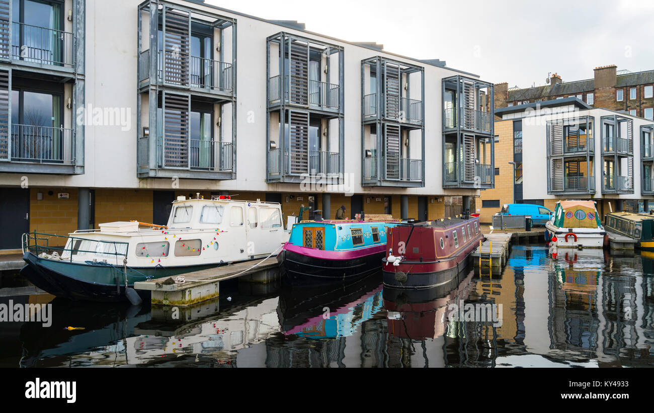 Vista del nuovo lato canale appartamenti e strette imbarcazioni al bacino Lochrin su Union Canal a Fountainbridge a Edimburgo, Scozia, Regno Unito. Foto Stock