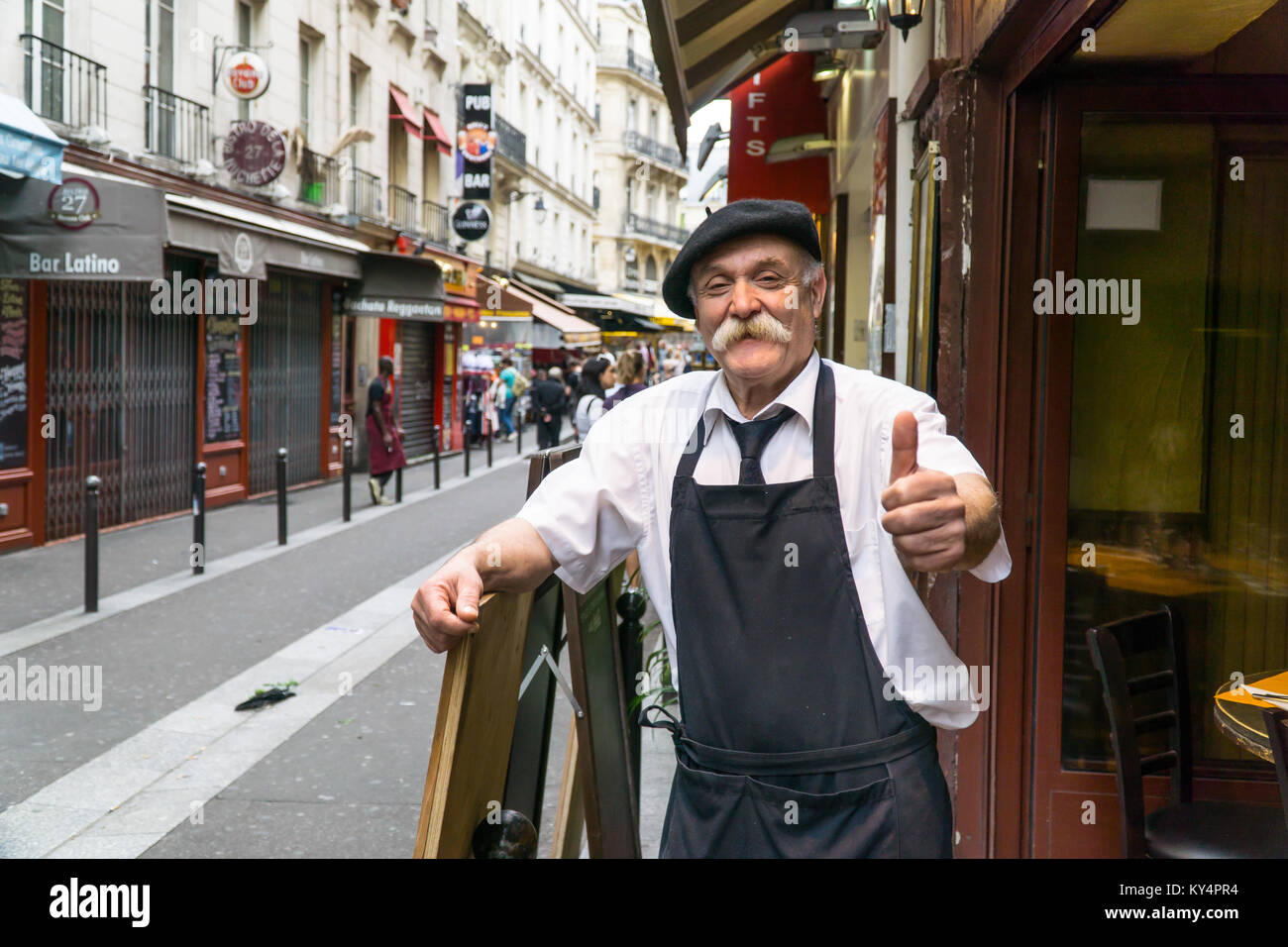 Ristoratore francese al di fuori dei suoi locali dando pollice fino al fotografo Foto Stock