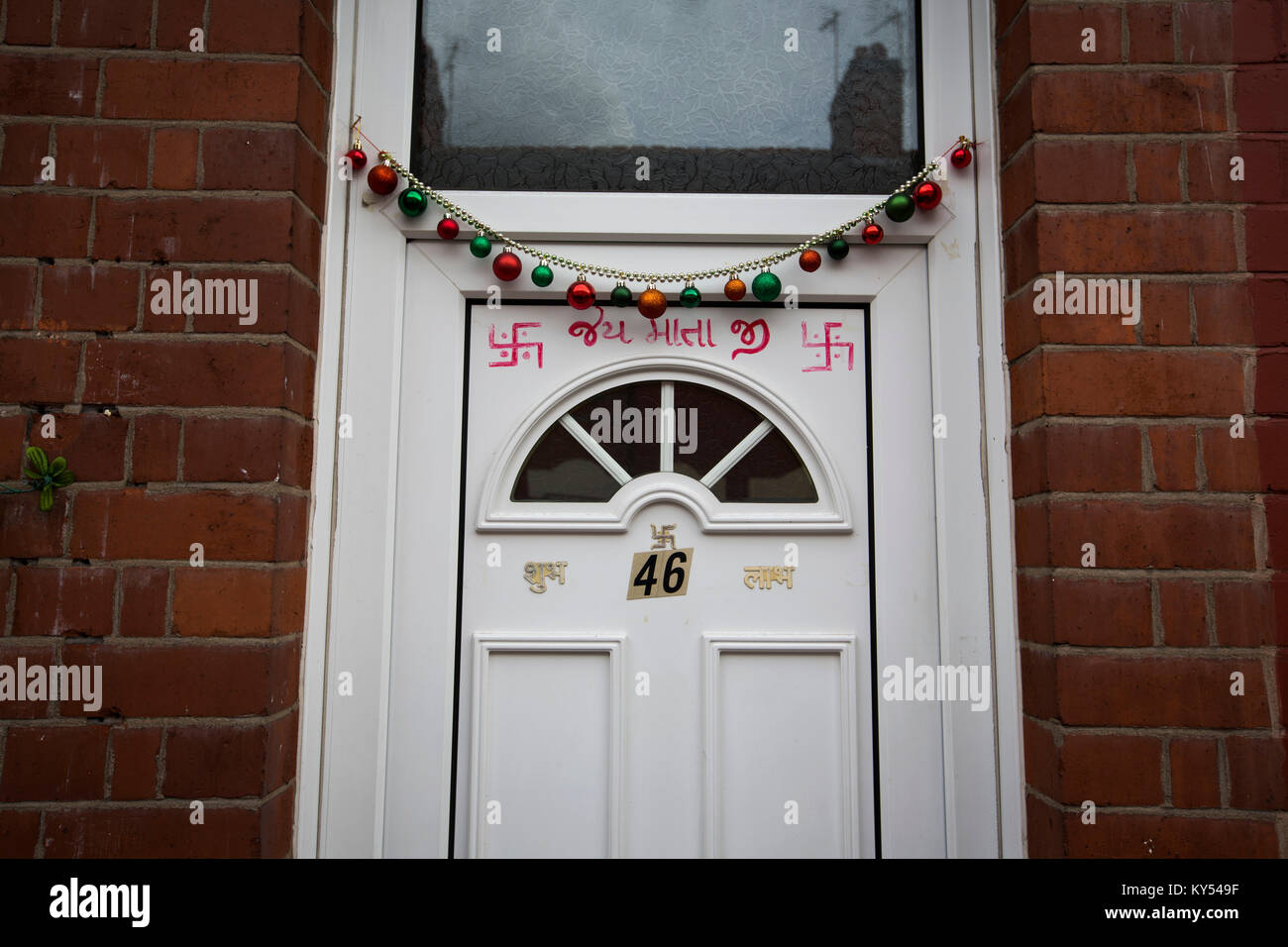 Una casa residenziale decorati con simboli indù nel Golden Mile distretto della città di Leicester nelle Midlands inglesi. Il quartiere è uno dei più grandi popolazioni di persone con un background Indiano nel Regno Unito. La locale squadra di calcio, il Leicester City, erano sull'orlo di essere sorpresa vincitori della Premier League inglese nella stagione 2015-16. Foto Stock