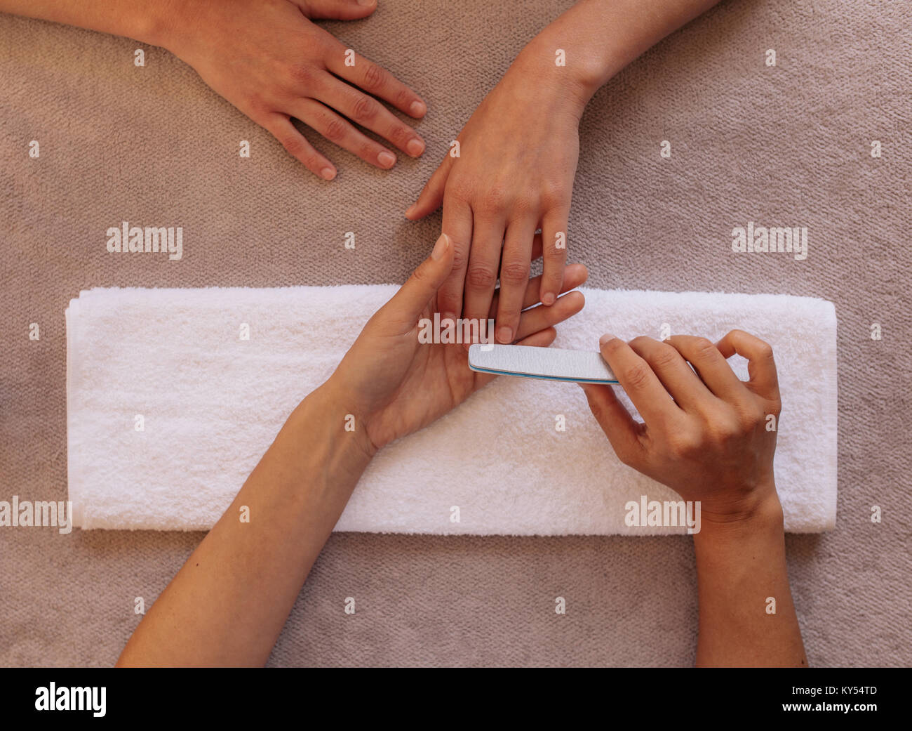 Vista superiore della donna nelle mani manicure ricevendo una manicure da manicurist. Estetista il deposito di clienti di sesso femminile unghie a spa salone di bellezza. Foto Stock