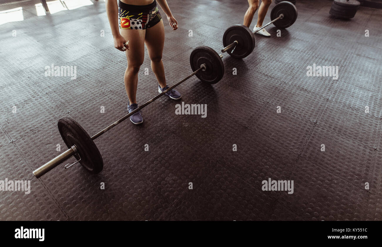 Le persone sane a palestra di allenamento con i pesi pesanti. La donna prima di esercitare con barbell in palestra. Foto Stock