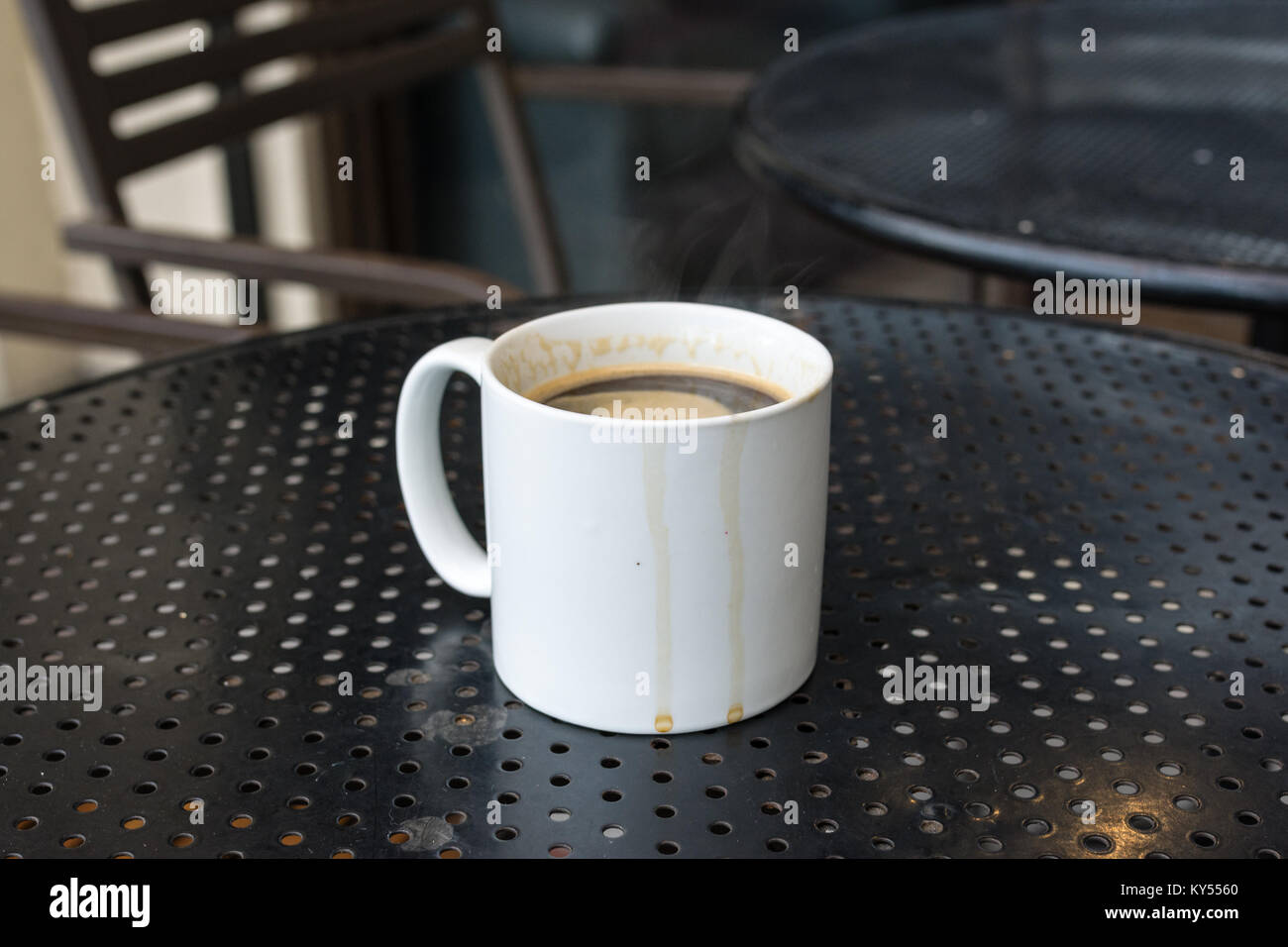 Caffè Americano in bianco standard mug su nero tavolo in metallo con caffè corre Foto Stock