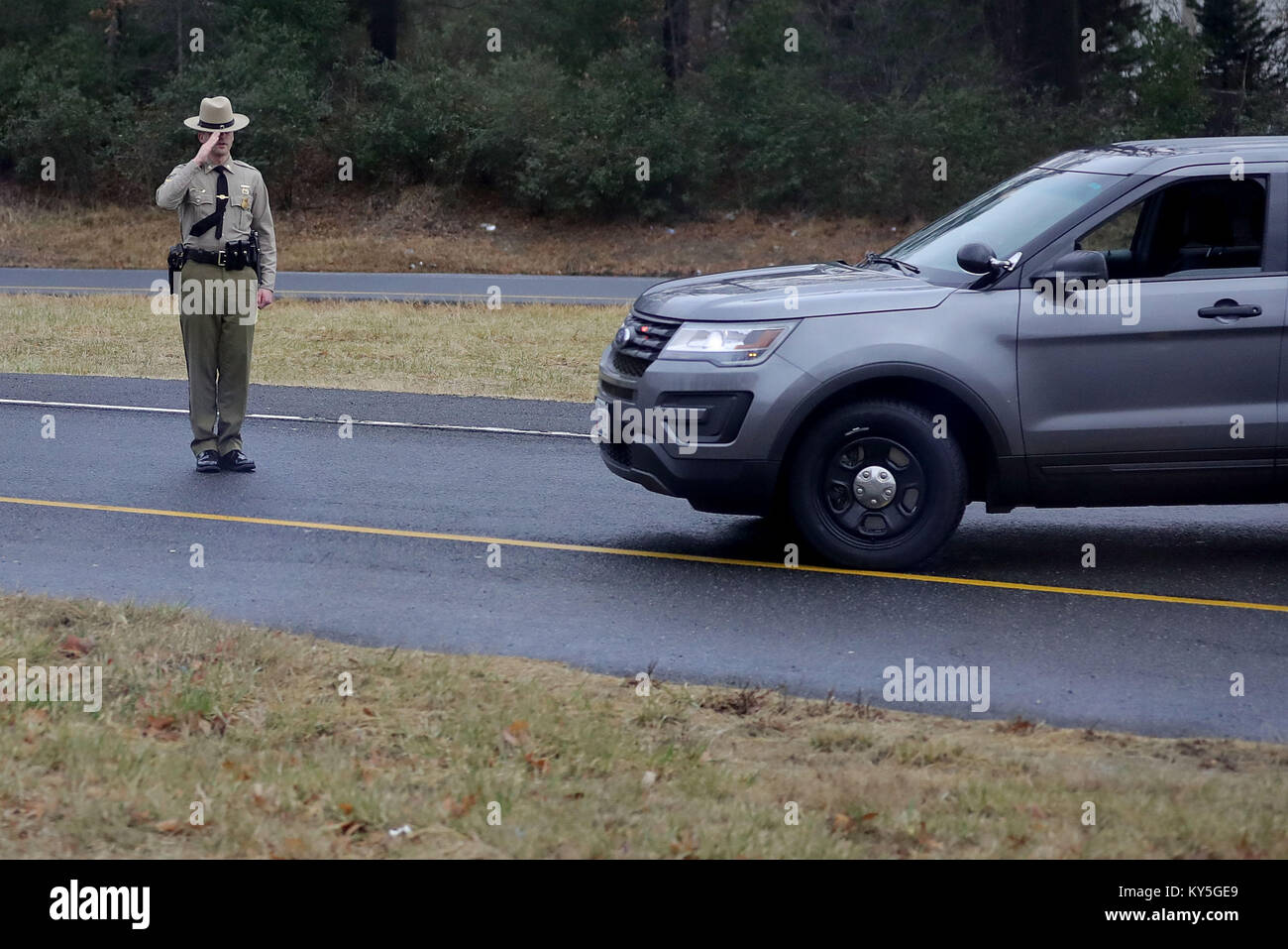 Un Maryland membro Trooper saluta come presidente degli Stati Uniti Trump di teste per il giro della Papamobile a Walter Reed Militare Nazionale Medical Center per il suo annuale esame fisico 12 gennaio 2018 di Bethesda, Maryland. Trump al prossimo viaggio in Florida per trascorrere il Dr Martin Luther King Jr day weekend di vacanza al suo Mar-a-Lago resort. Credit: Chip Somodevilla/Piscina via CNP /MediaPunch Foto Stock