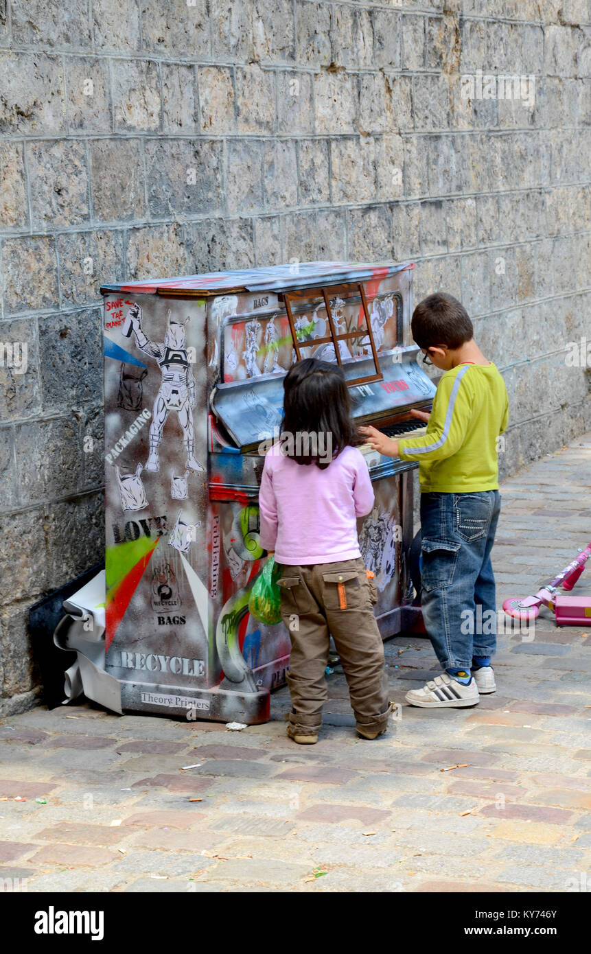 Gioca sono tuo. Piano lasciato in strada per chiunque per giocare, di Luke Jerram. A Montmartre Parigi, Francia, Europa. Bambini che suonano piano all'esterno Foto Stock