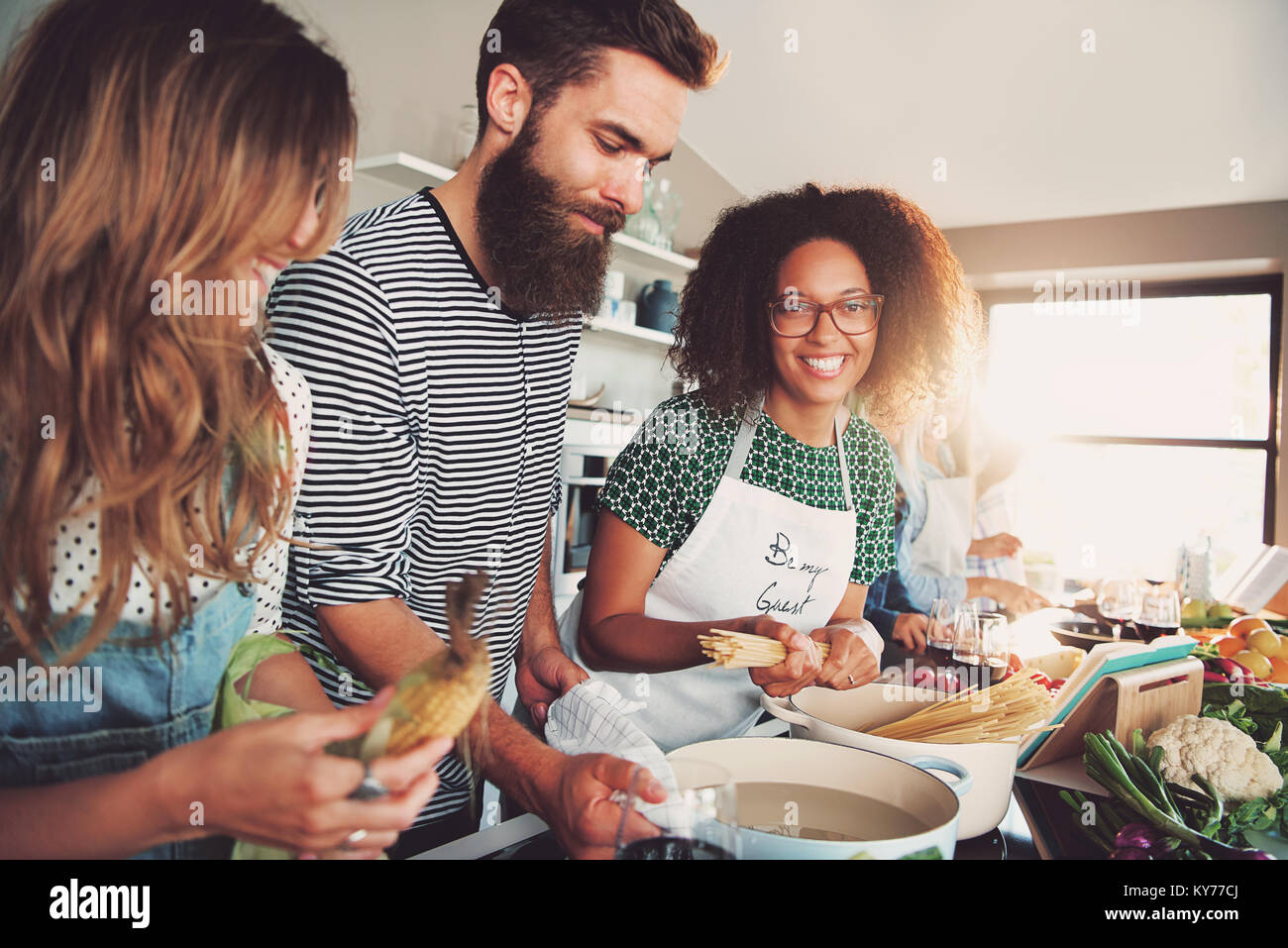 Foto di gruppo dei tre amici alla preparazione del cibo per la cena Foto Stock