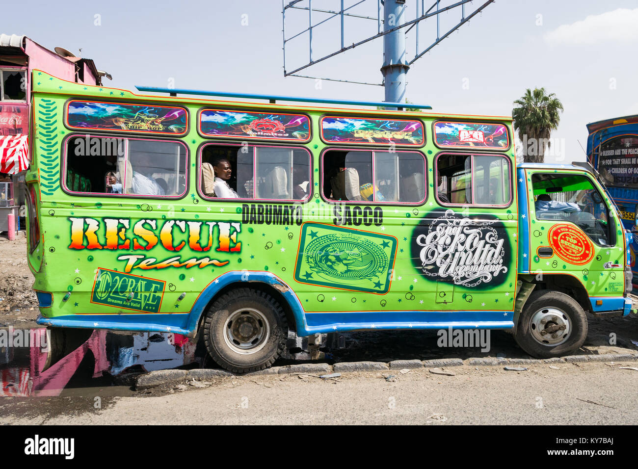 Un vivacemente colorato autobus con passeggeri attende sulla strada nel traffico, Nairobi, Kenya, Africa orientale Foto Stock