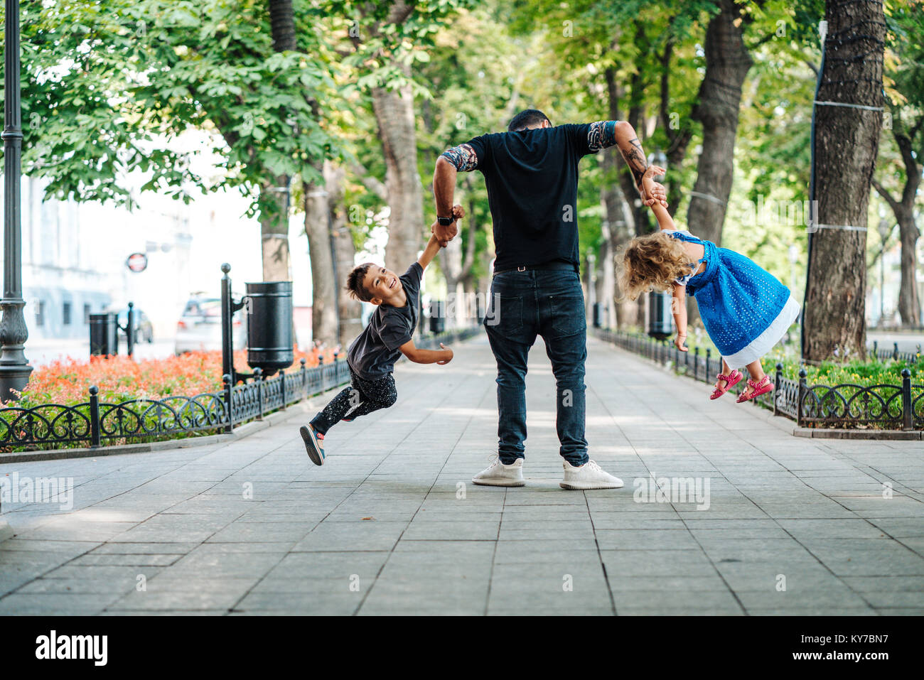 I bambini si divertono con il papà nel parco Foto Stock