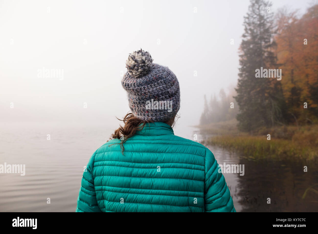 MAYNOOTH, Ontario, Canada - 18 Ottobre 2017: Una signora guarda a un lago di nebbia in autunno. Foto Stock