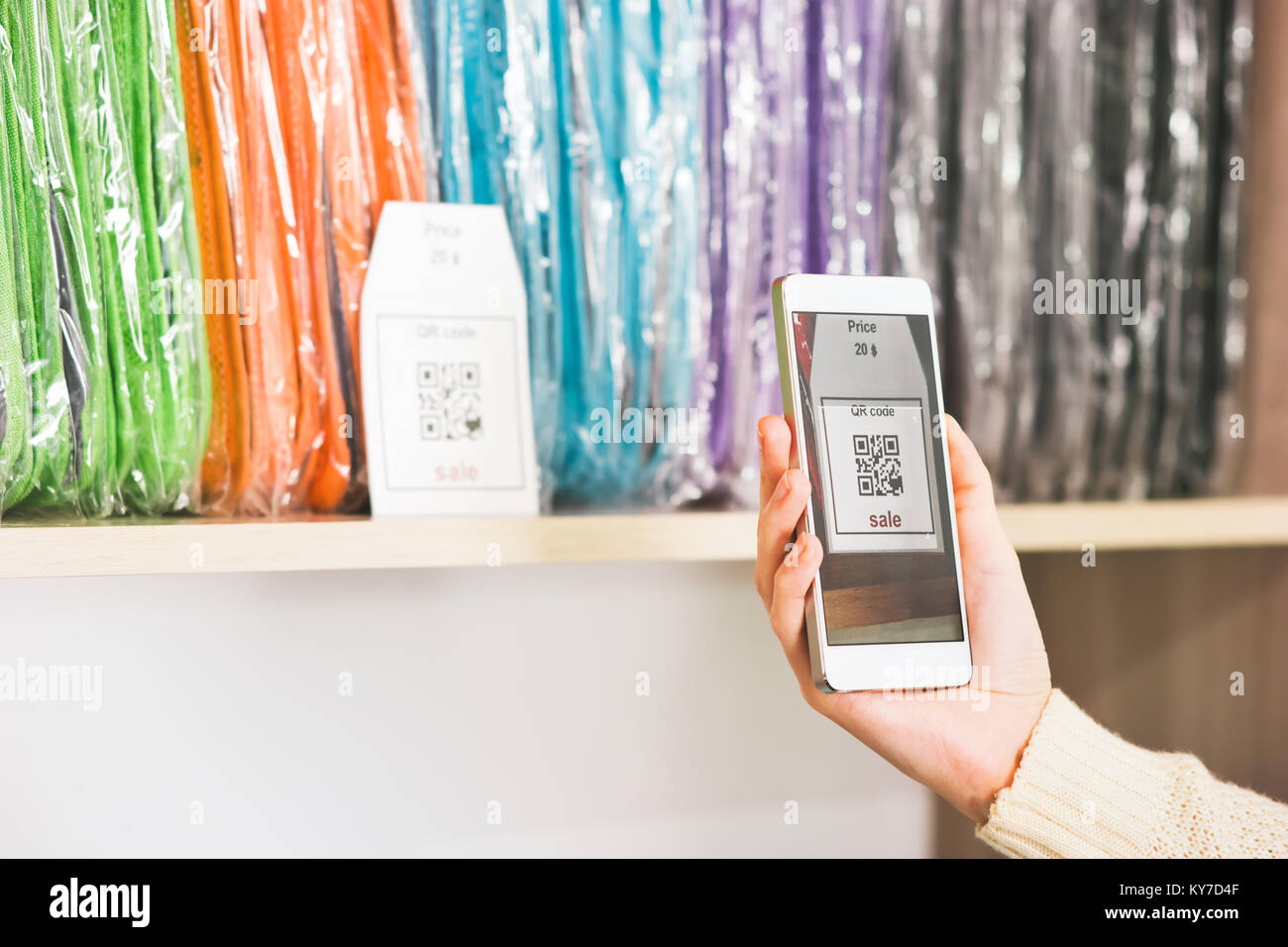 Scansione a mano il codice QR con smartphone in vetrina pubblicità vendita shopping moderno concetto di tecnologia Foto Stock