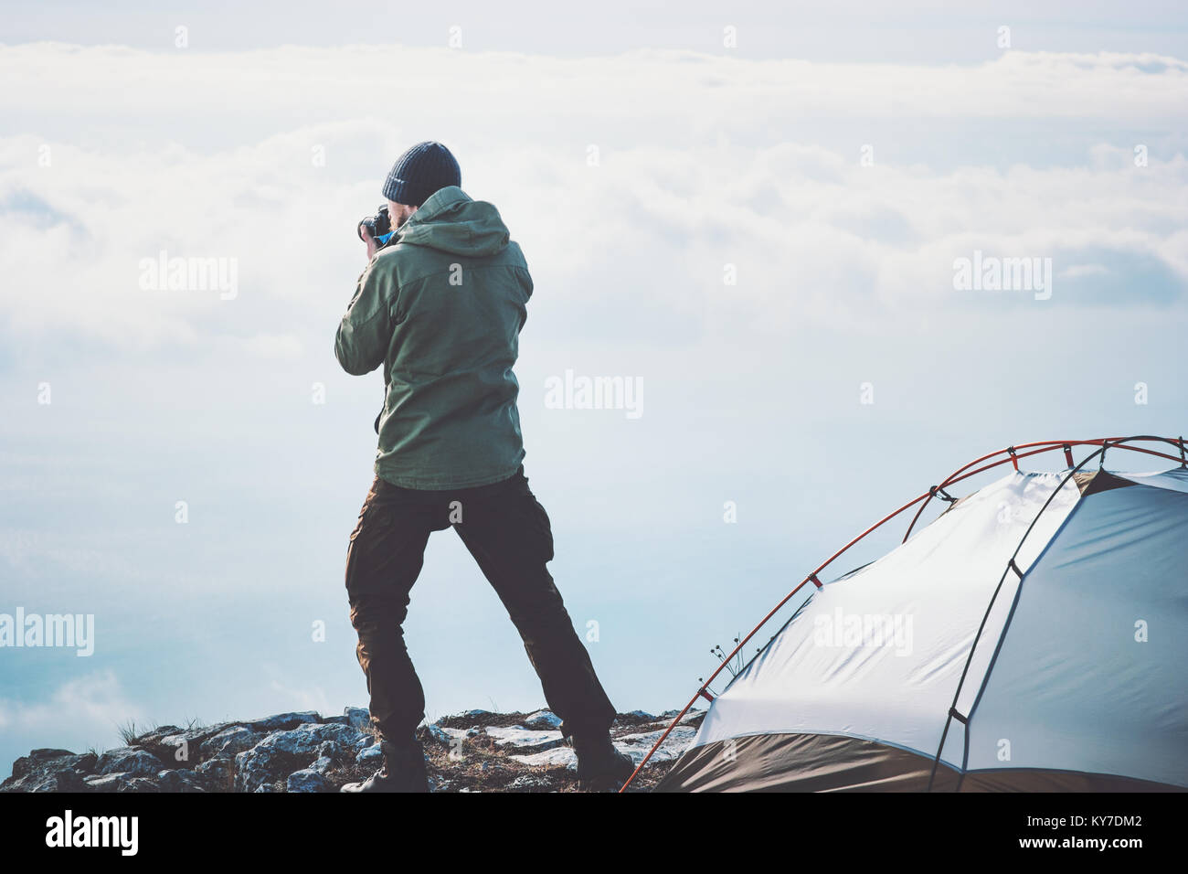 L'uomo fotografo con foto di ripresa della telecamera foggy montagne nuvole paesaggio dalla tenda da campeggio lo stile di vita di viaggio concetto Vacanze avventura all'aperto Foto Stock