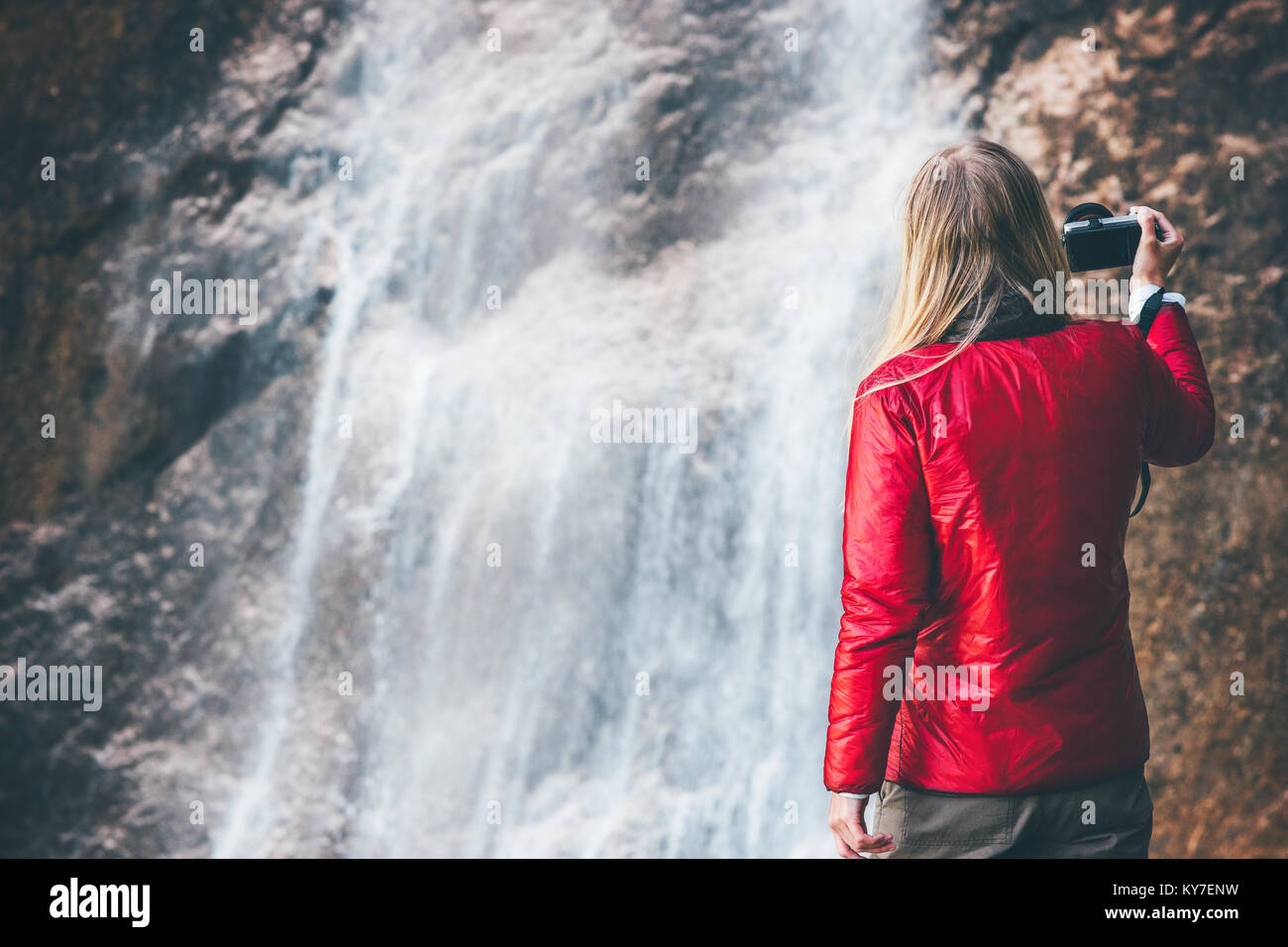 Donna fotografo godendo waterfall Travel Lifestyle adventure concept vacanze attive nel selvaggio in armonia con la natura Foto Stock