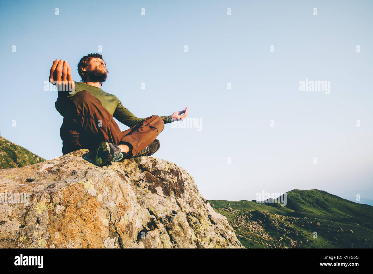 Uomo in meditazione yoga lotus pongono a montagne stile di vita viaggio emotivo relax concetto estate vacanze outdoor in armonia con la natura seduta su roccia Foto Stock