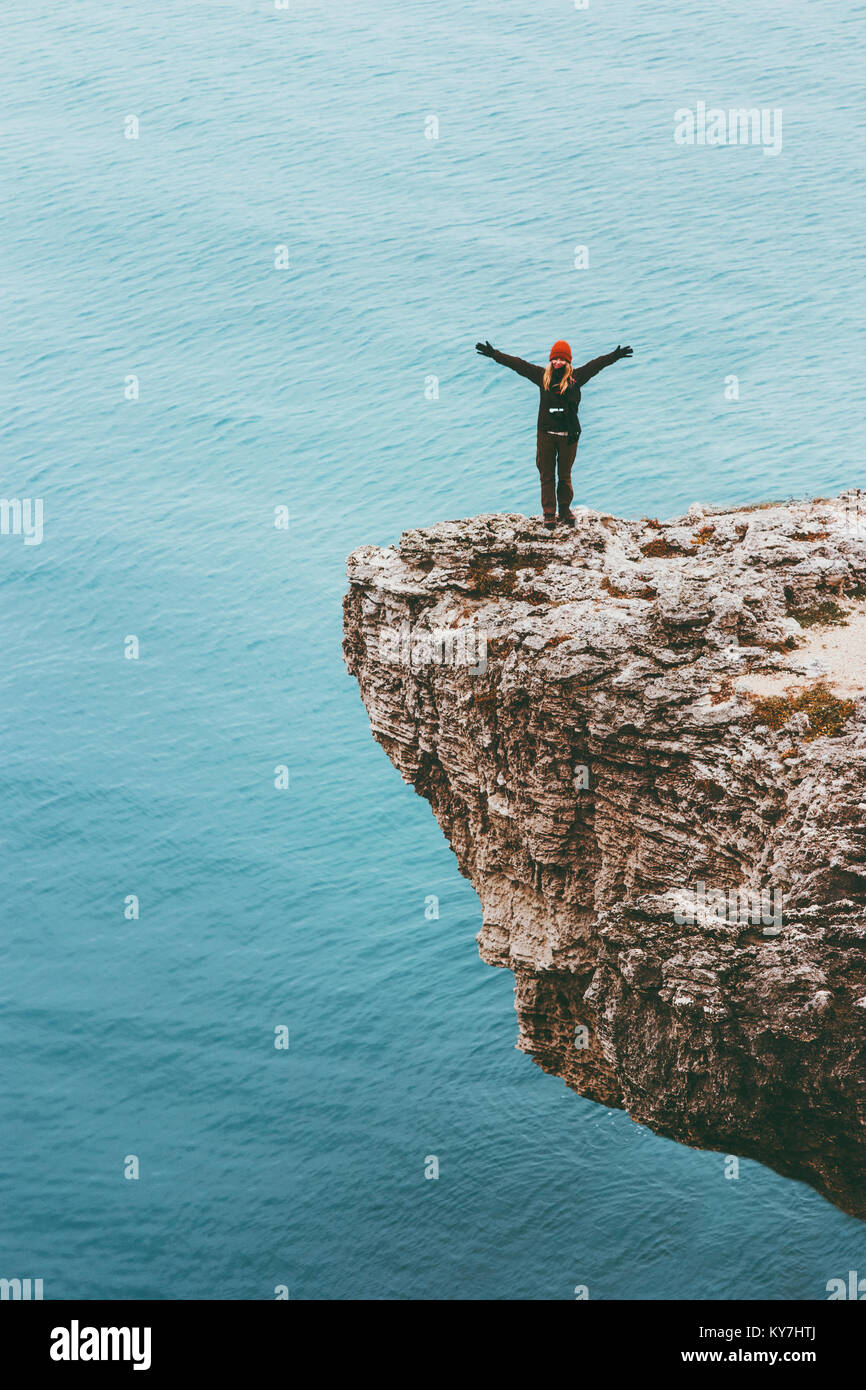 Viaggiatore contento scogliera sul mare sopra le mani alzate stile di vita viaggio motivazione successo concetto avventura vacanze attive outdoor in armonia con la natura Foto Stock