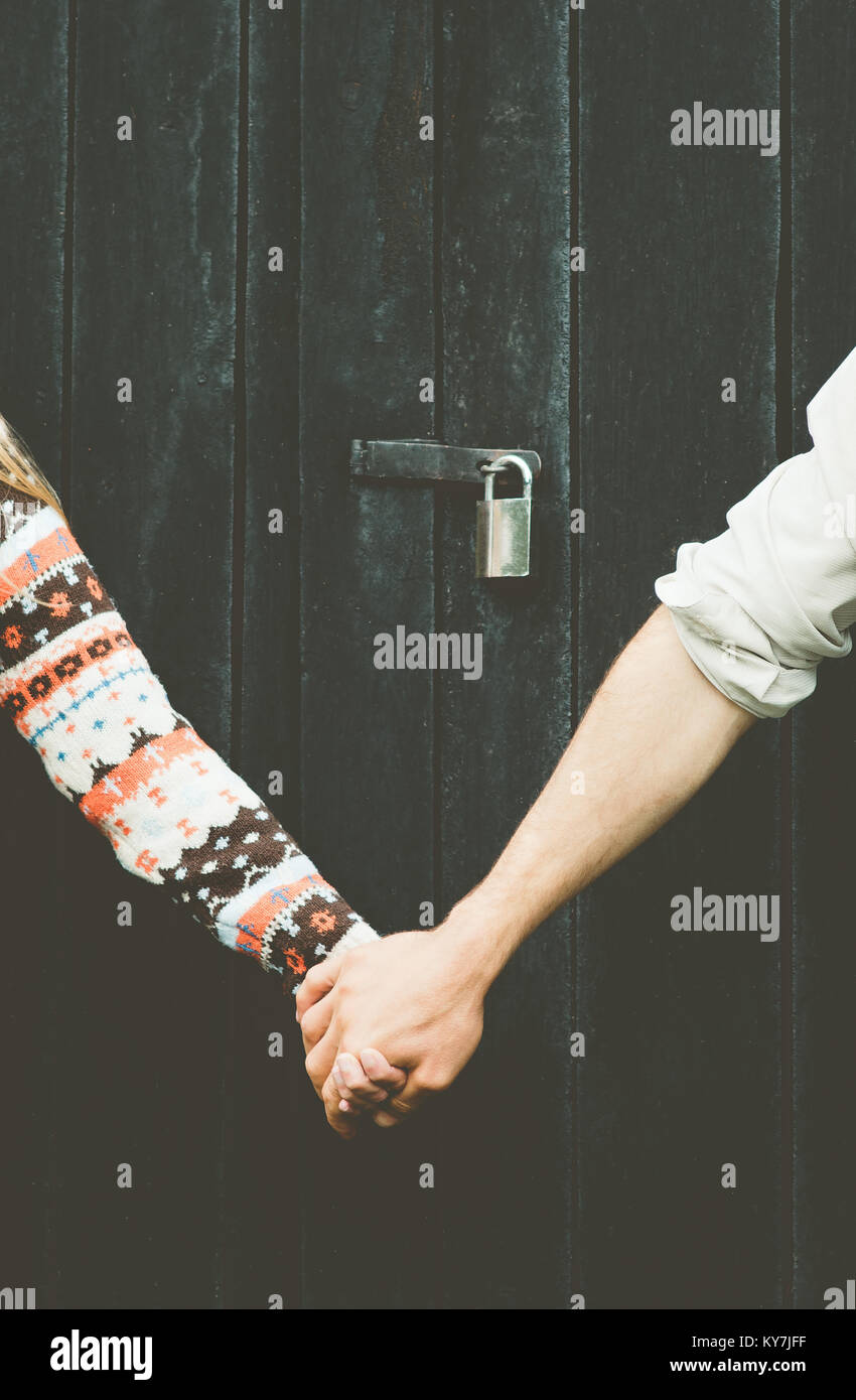 Amore giovane mani per sempre insieme allo stile di vita di sfondo di legno e bloccare su persone concetto tabù Foto Stock