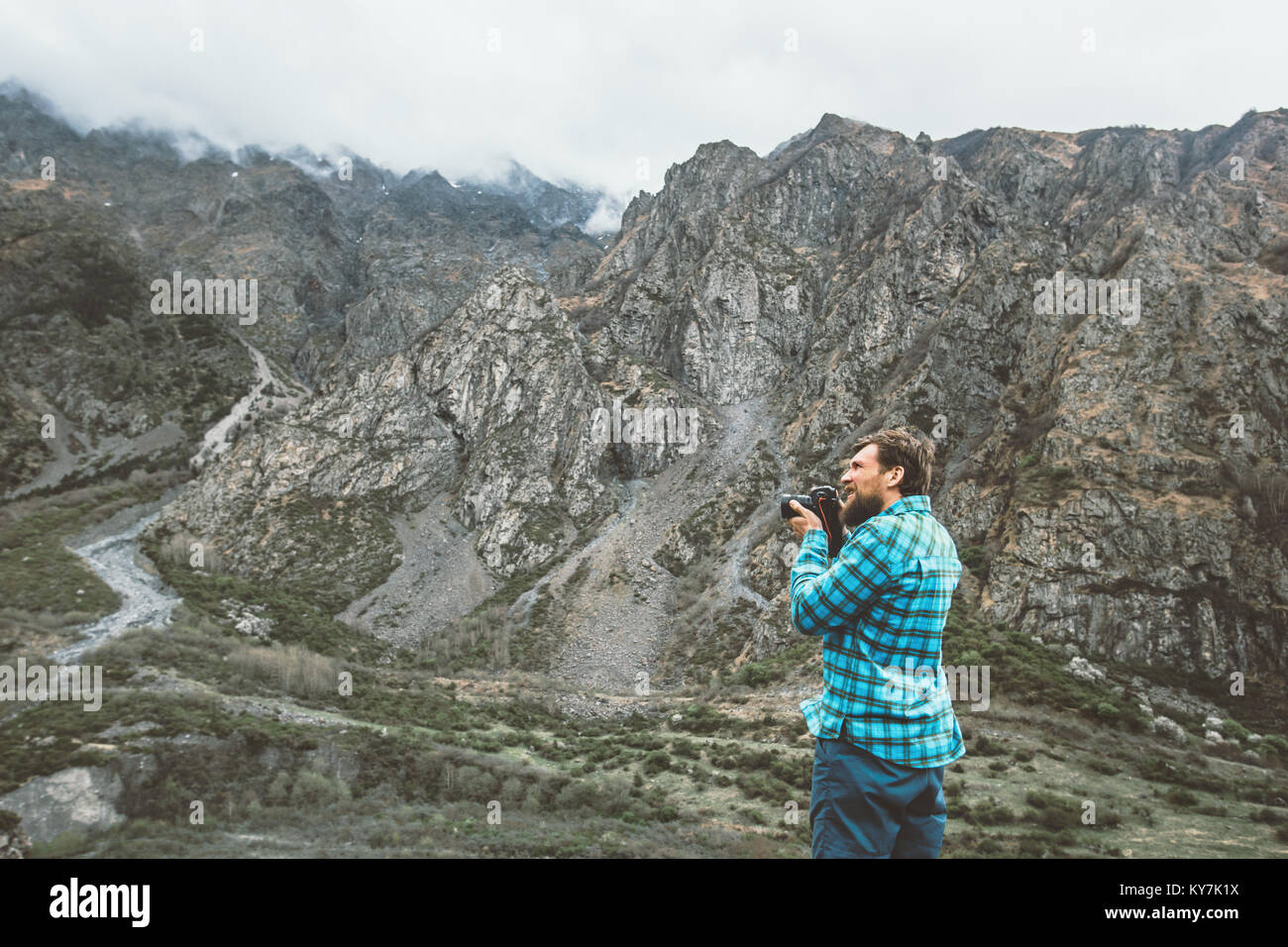 L'uomo fotografo con fotocamera prendendo foto di foggy montagne stile di vita viaggio concetto hobby avventura vacanze attive outdoor Foto Stock