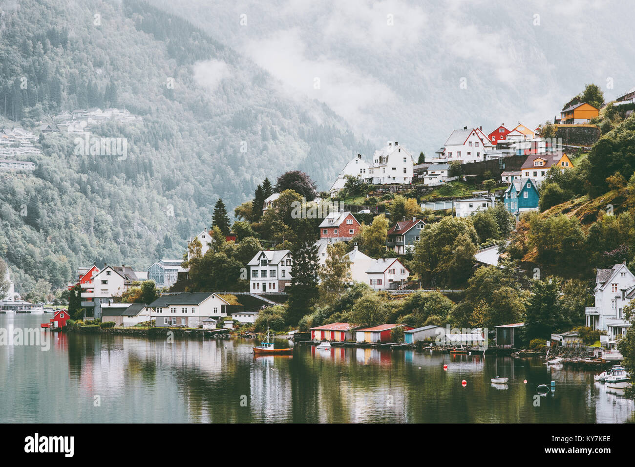Odda case di città in Norvegia paesaggio delle montagne di nebbia e di riflessione di acqua Foto Stock