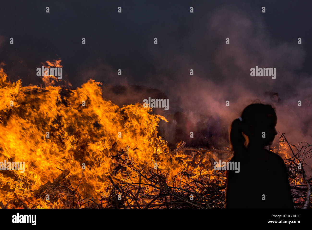 Ragazza di fronte di fiamme di fuoco di notte, Danimarca, Giugno23, 2017 Foto Stock