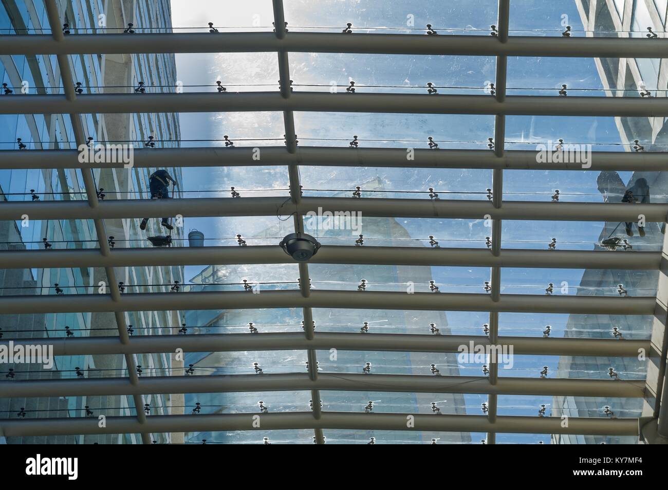 Due lavoratori pulire il tetto di vetro di un centro commerciale di Città del Messico. Foto Stock