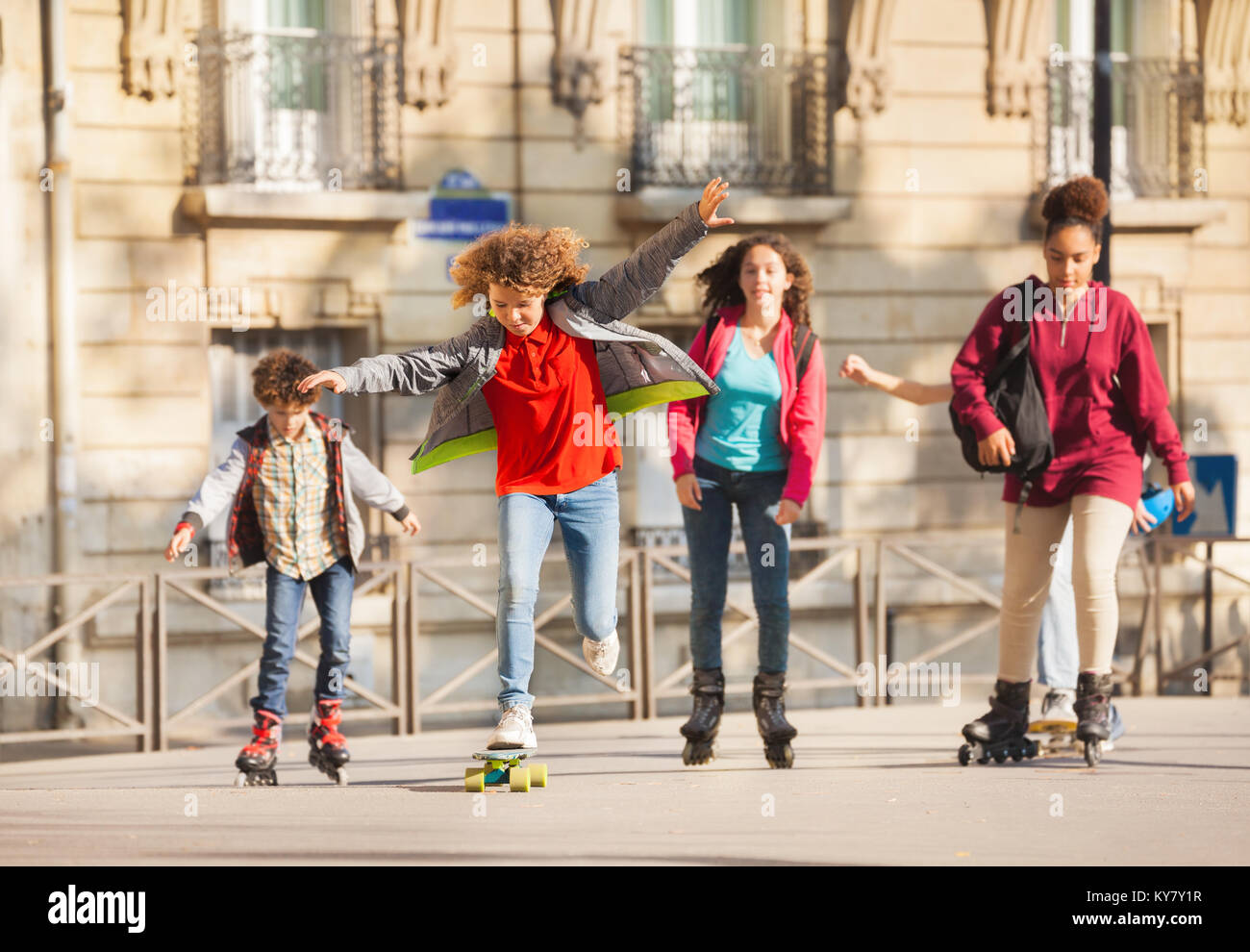 Gruppo di adolescenti, happy amici, skateboard e roller lungo la strada di città Foto Stock