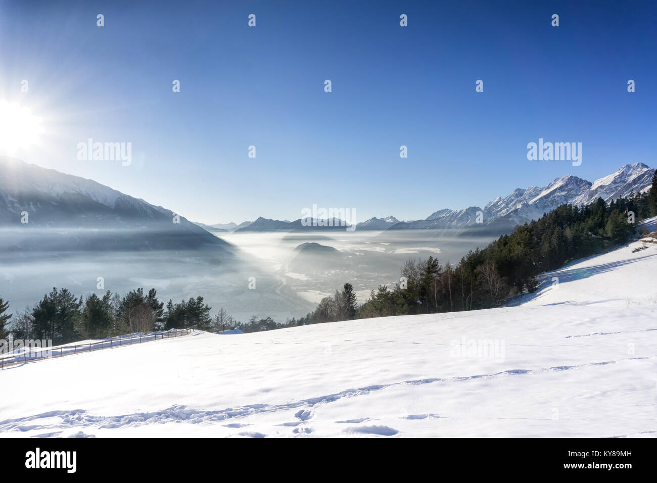 In inverno il paesaggio di montagna. Blu cielo con sole luminoso, nebbia nella valle. Tirol, Alpi, Austria. Foto Stock