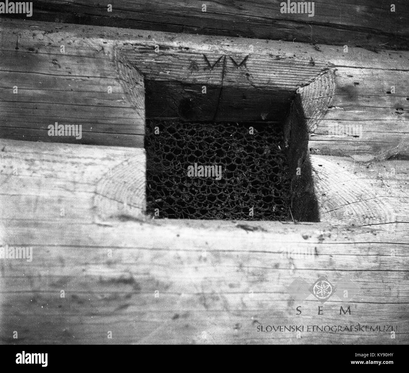 Una finestra su un granaio a Paradišče, 1949, mostra un simbolo magico scolpito, che illustra le pratiche popolari tradizionali e l'architettura rurale nella Slovenia del dopoguerra. Foto Stock