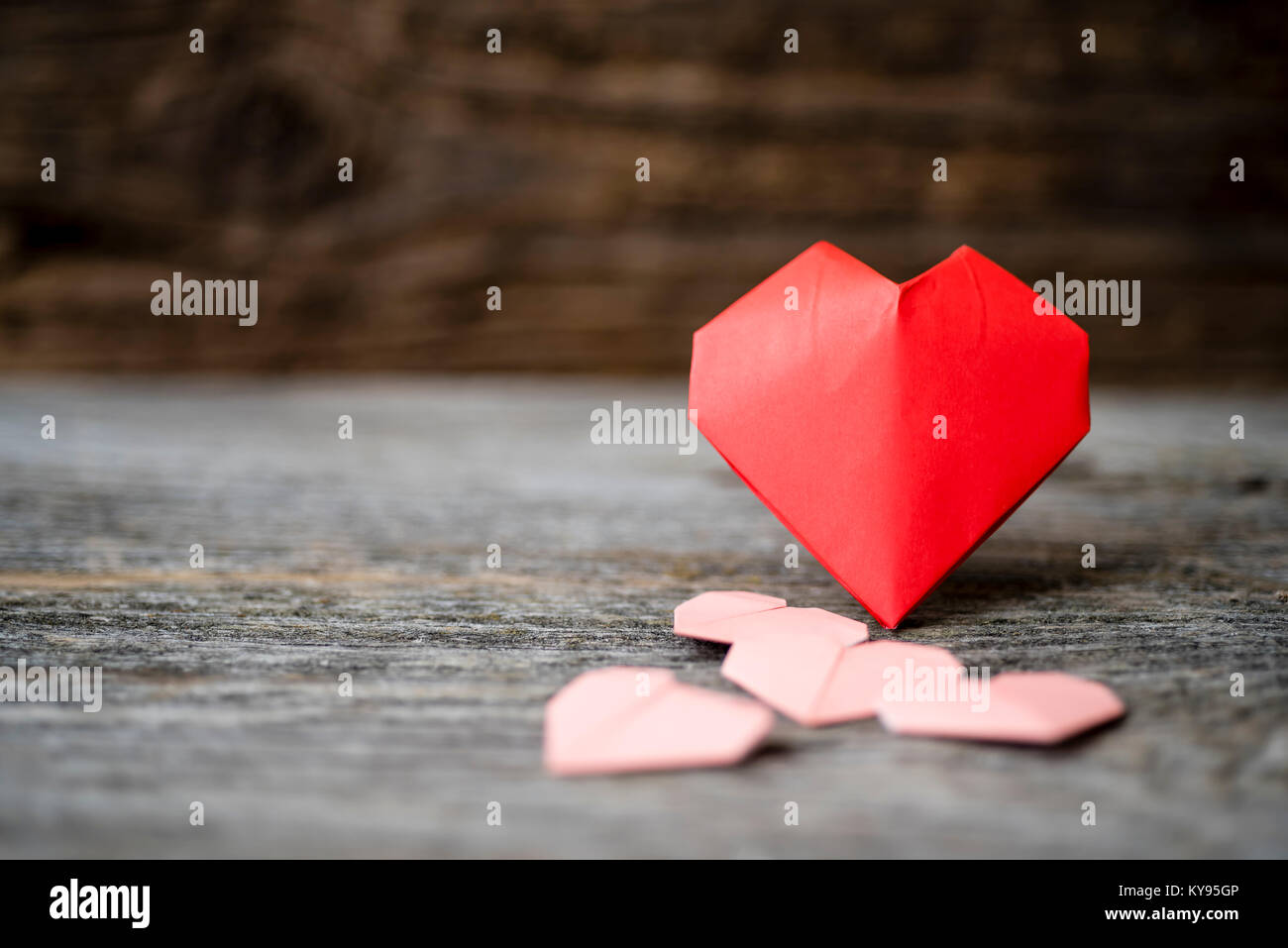 Raccolta orizzontale di diversi formati di carta origami cuori per il giorno di San Valentino shot contro il fienile rustico sfondo legno Foto Stock