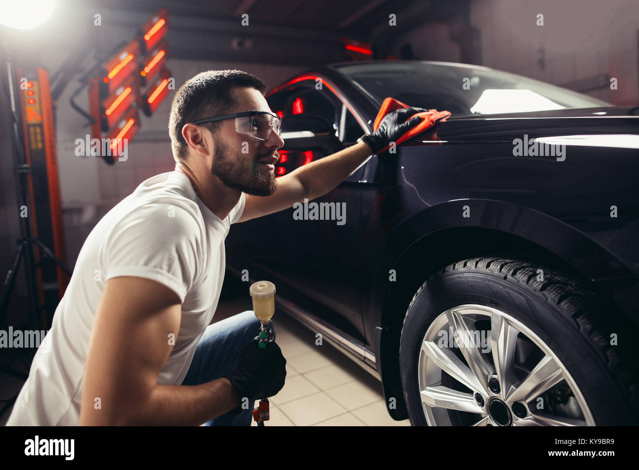 Dettagli auto - l'uomo detiene la microfibra in mano e leviga la vettura Foto Stock