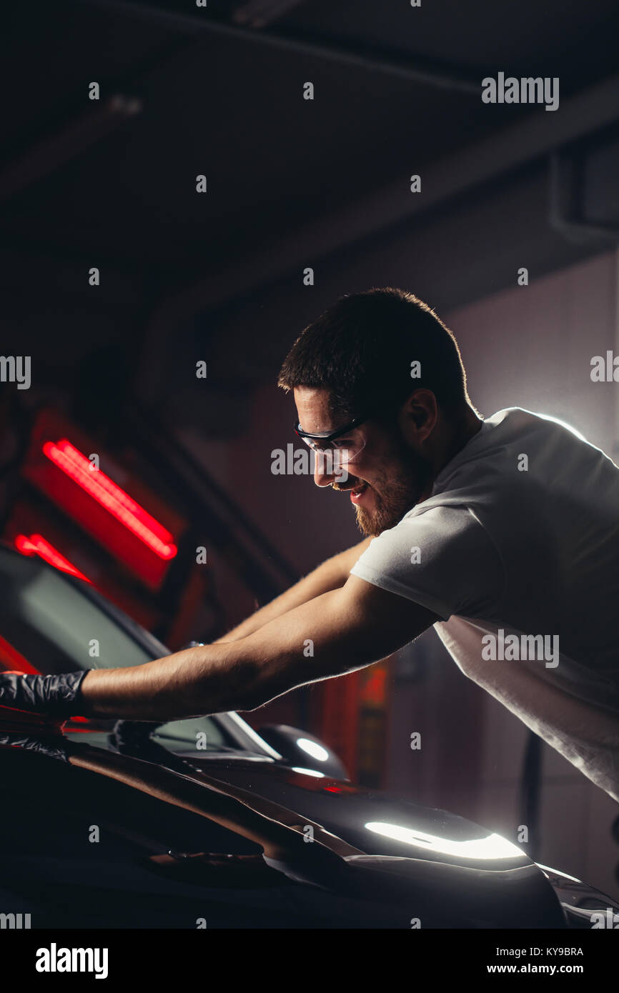 Uomo Macchina di pulizia con un panno in microfibra, auto che dettaglia o concetto valeting Foto Stock