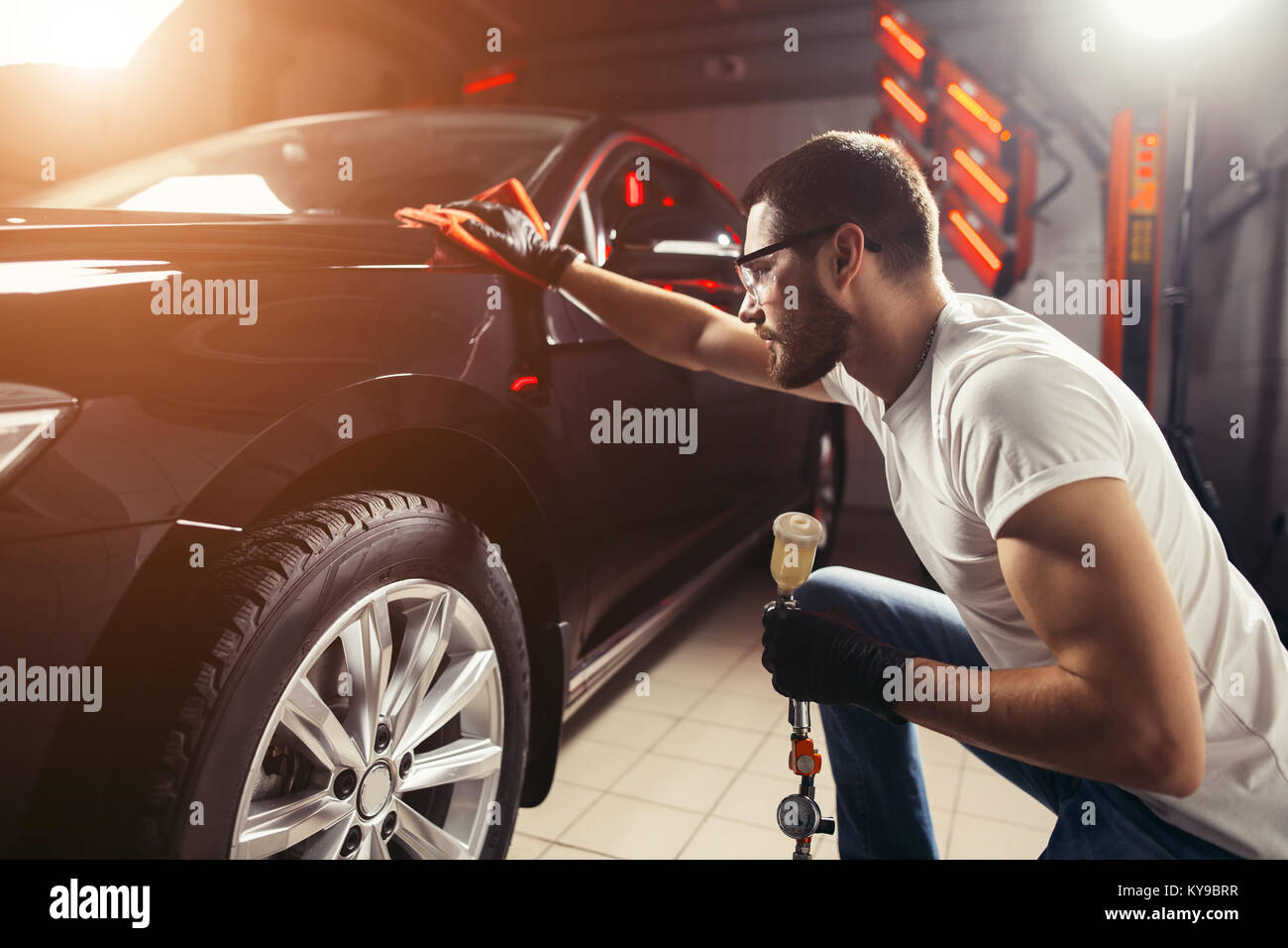 Uomo Macchina di pulizia con un panno in microfibra, auto che dettaglia o concetto valeting Foto Stock