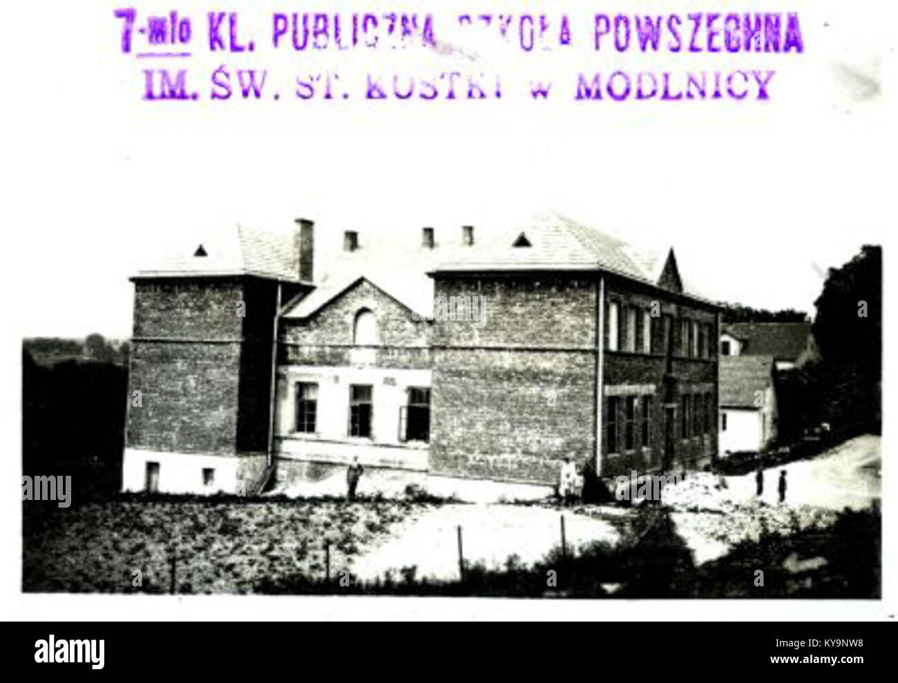 Una fotografia della scuola di Modlnica, Polonia, scattata nel 1929, che mostra l'edificio scolastico, gli studenti e l'ambiente educativo nel periodo tra le due guerre. Foto Stock