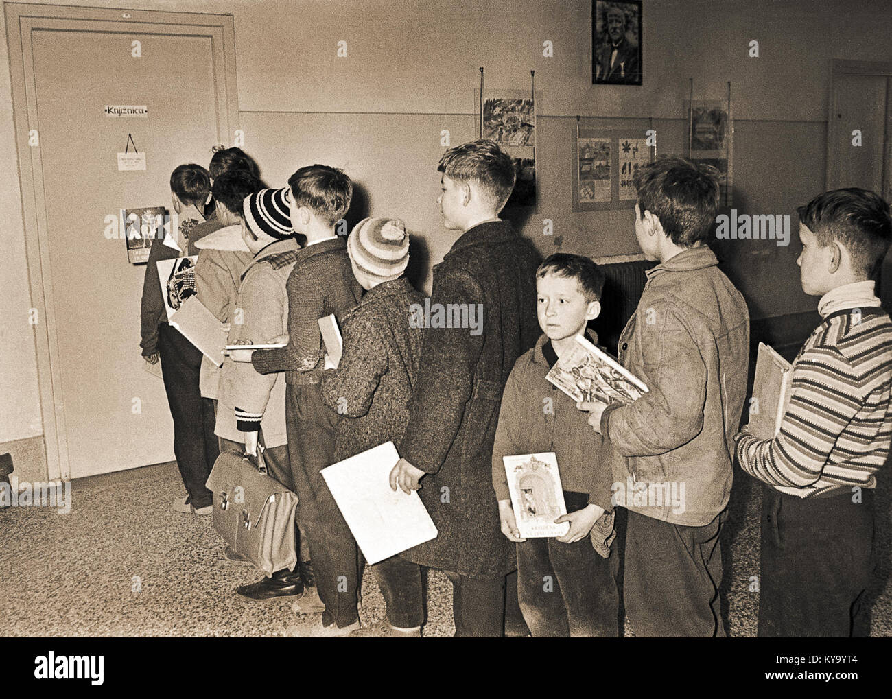 Questa fotografia del 1964 mostra l'area di fronte alla biblioteca della Scuola Polulska di Celje, Slovenia, catturando il contesto architettonico e sociale dell'ambiente scolastico durante la metà del XX secolo. Foto Stock